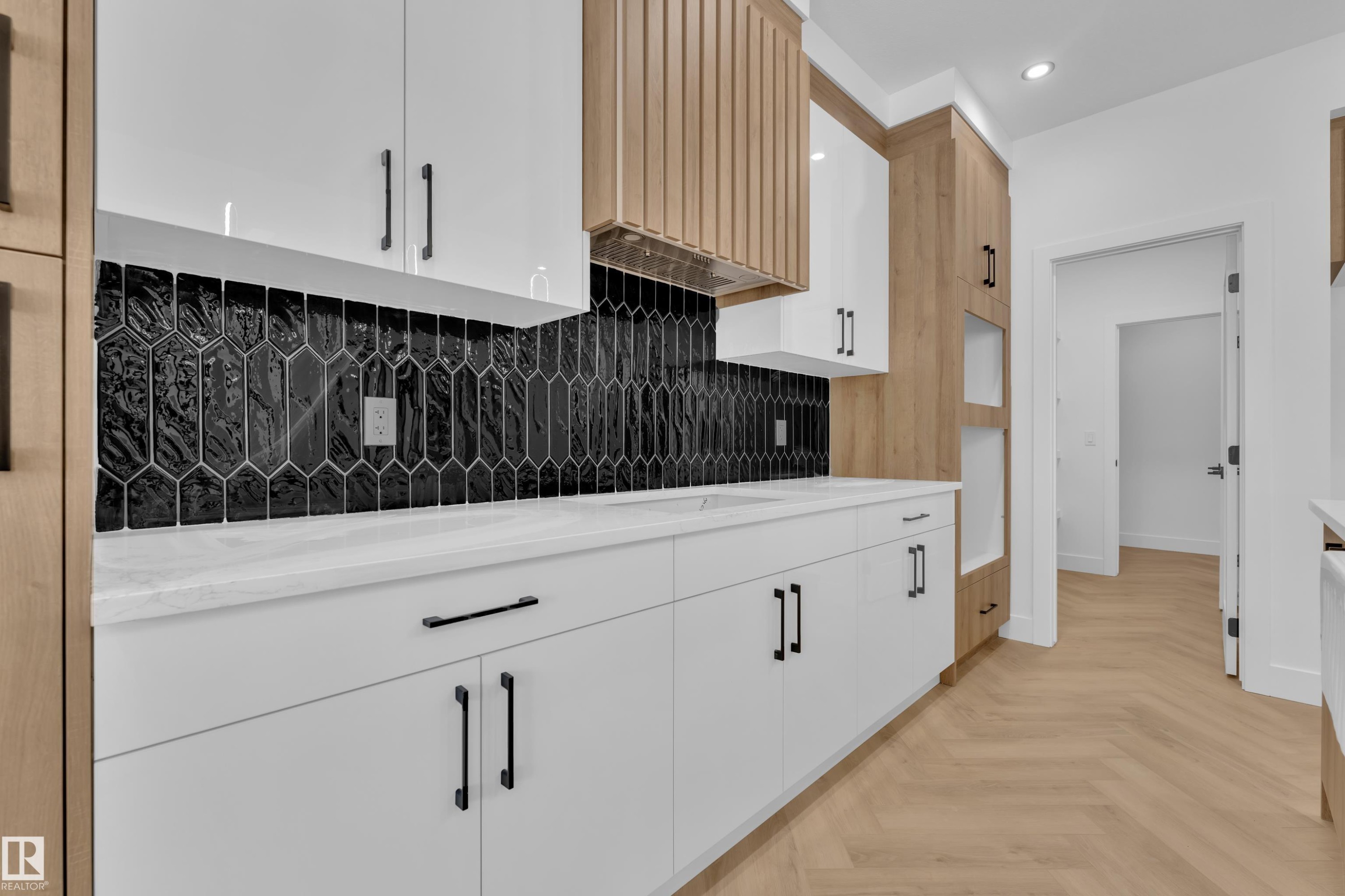 Kitchen with parquet floors, white cabinets, recessed lighting, tasteful backsplash, and light stone countertops - 737 Astoria Way, Devon, AB - Indoor