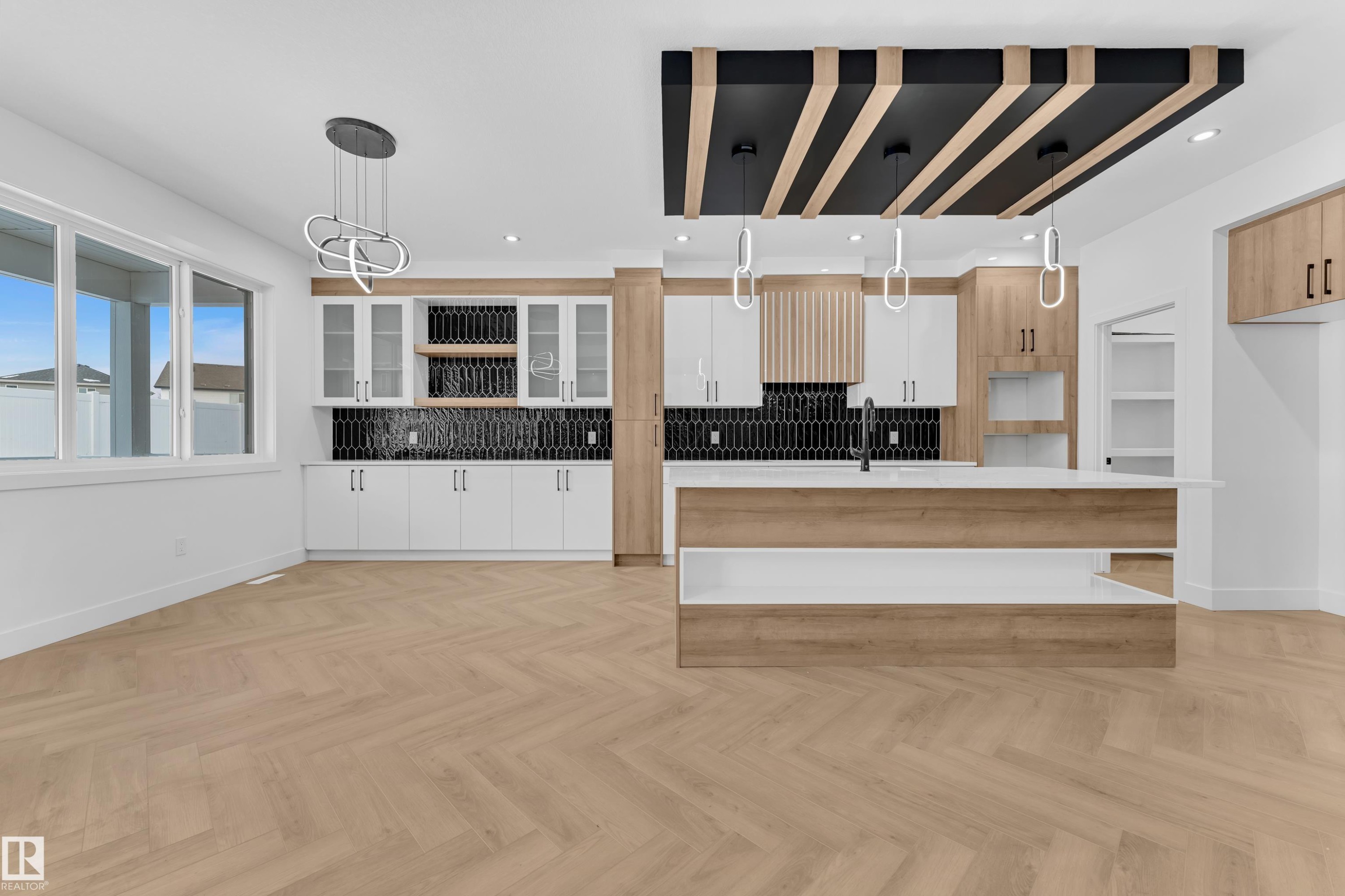 Kitchen featuring parquet flooring, a kitchen island with sink, hanging light fixtures, decorative backsplash, and modern cabinets - 737 Astoria Way, Devon, AB - Indoor Photo Showing Kitchen