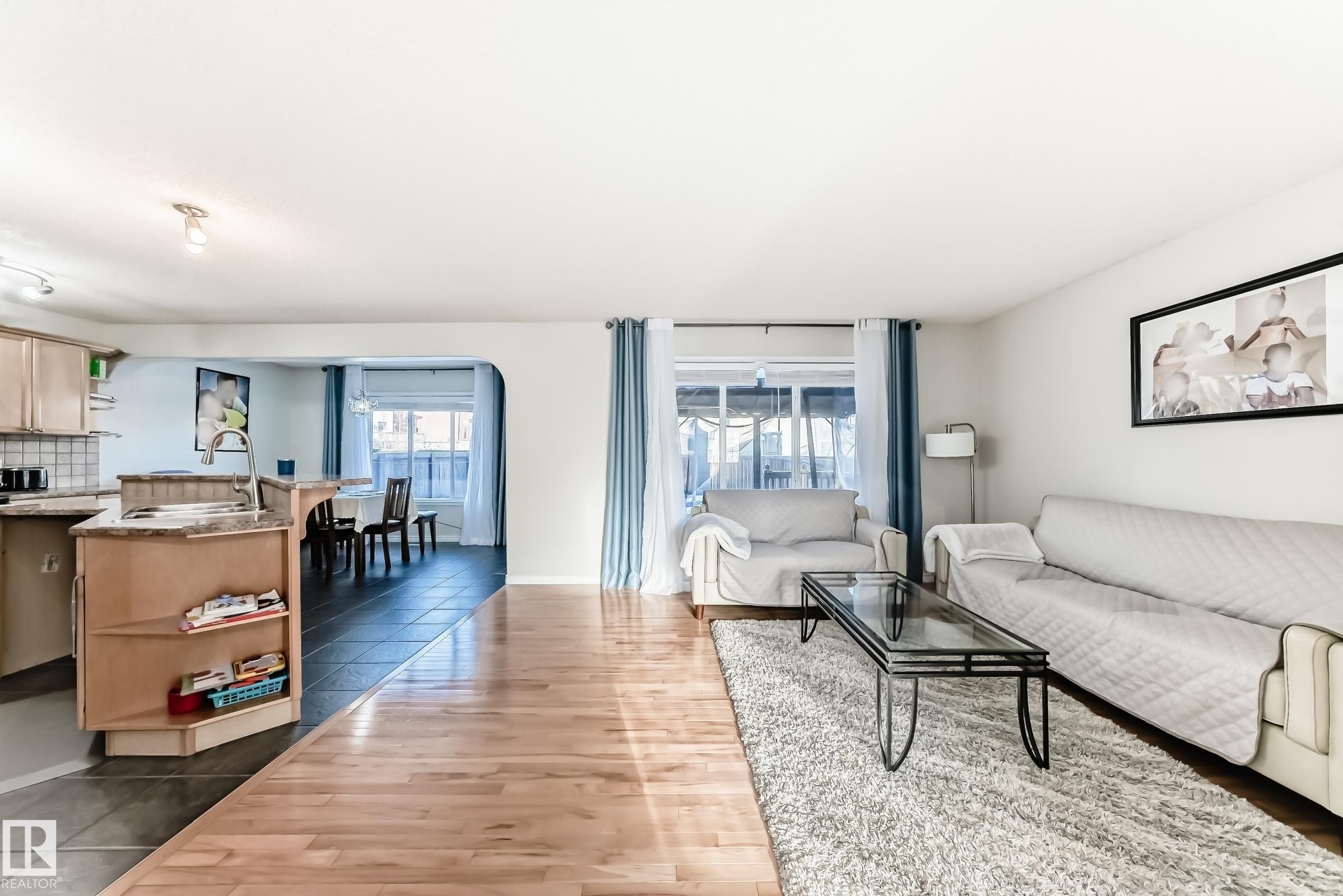 Living area with light wood-style flooring and arched walkways - 5814 165 Avenue, Edmonton, AB - Indoor Photo Showing Living Room