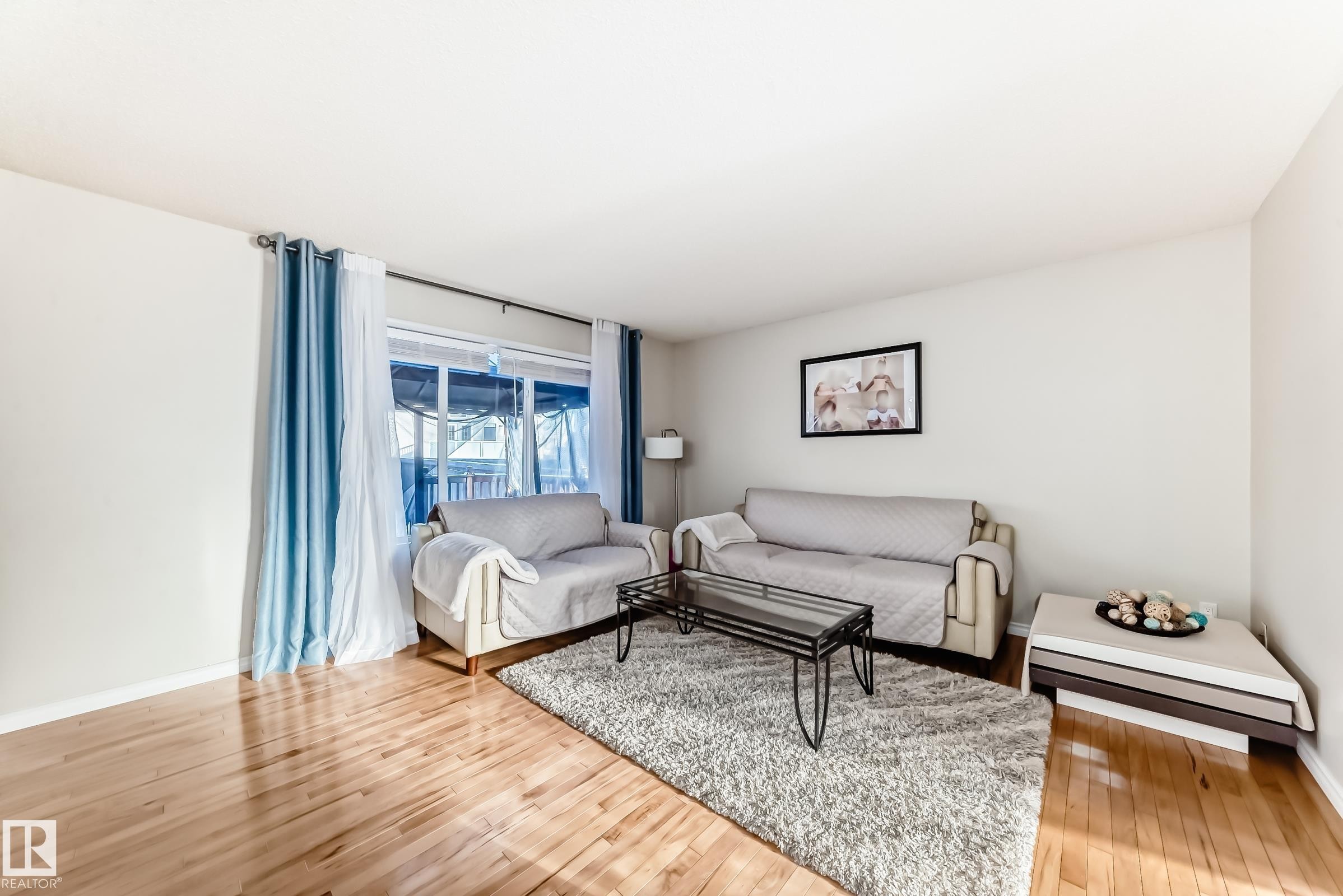 Living room featuring baseboards and light wood finished floors - 5814 165 Avenue, Edmonton, AB - Indoor Photo Showing Living Room