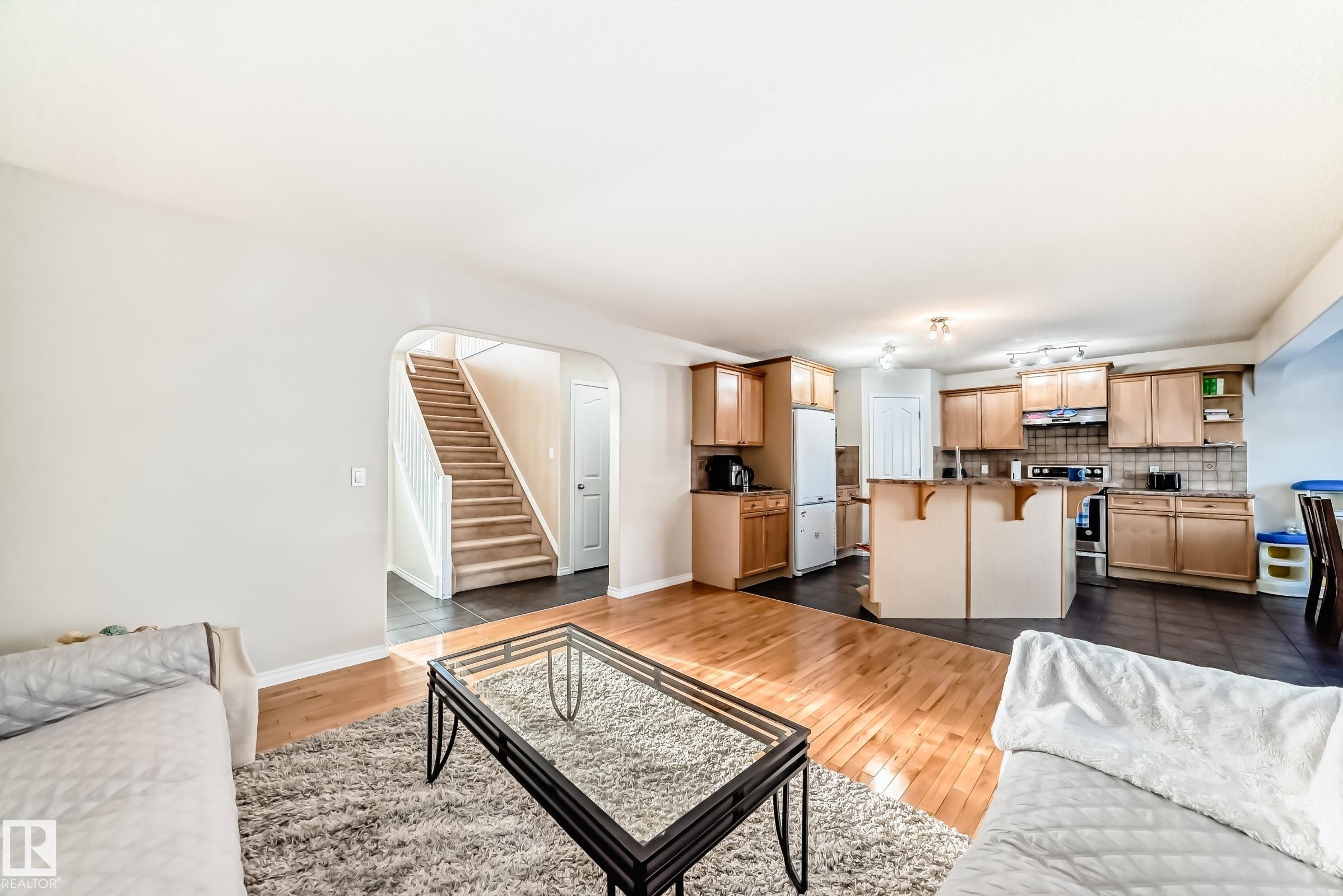 Living area with arched walkways and dark wood finished floors - 5814 165 Avenue, Edmonton, AB - Indoor Photo Showing Living Room
