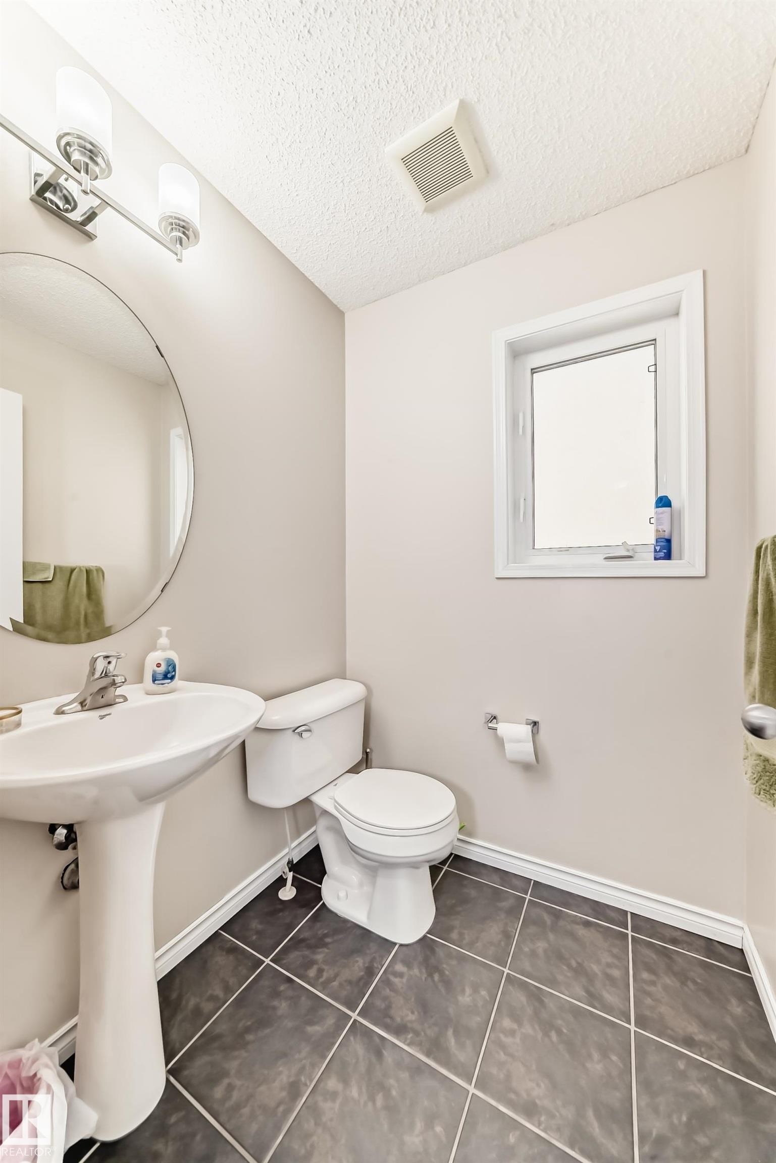 Bathroom with dark tile patterned floors and a textured ceiling - 5814 165 Avenue, Edmonton, AB - Indoor Photo Showing Bathroom