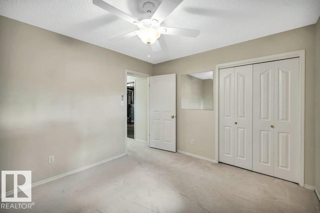 Unfurnished bedroom with a textured ceiling, a closet, ceiling fan, and light colored carpet - 112 Haddow Close, Edmonton, AB - Indoor