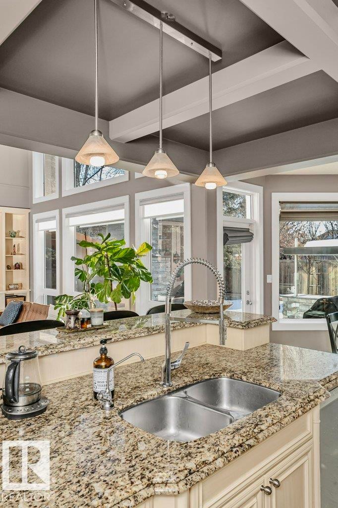 Kitchen featuring light stone countertops and decorative light fixtures - 1579 Hector Road, Edmonton, AB - Indoor Photo Showing Kitchen With Double Sink