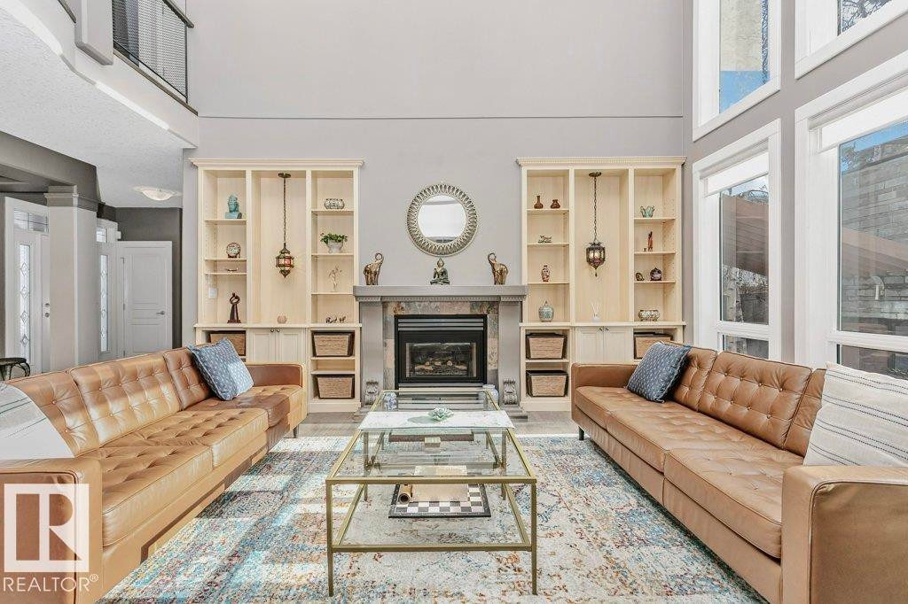 Living room with a high ceiling and a glass covered fireplace - 1579 Hector Road, Edmonton, AB - Indoor Photo Showing Living Room With Fireplace