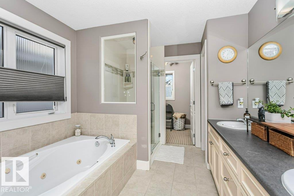 Bathroom with double vanity, a shower stall, a tub with jets, and light tile patterned flooring - 1579 Hector Road, Edmonton, AB - Indoor Photo Showing Bathroom