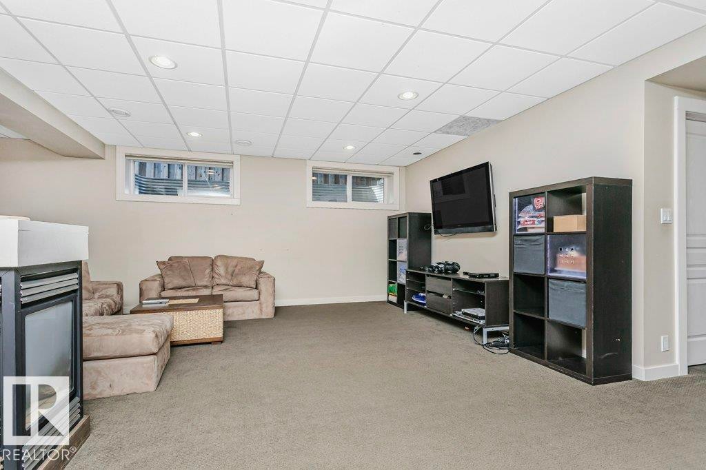 Living room with recessed lighting, light colored carpet, and a paneled ceiling - 1579 Hector Road, Edmonton, AB - Indoor