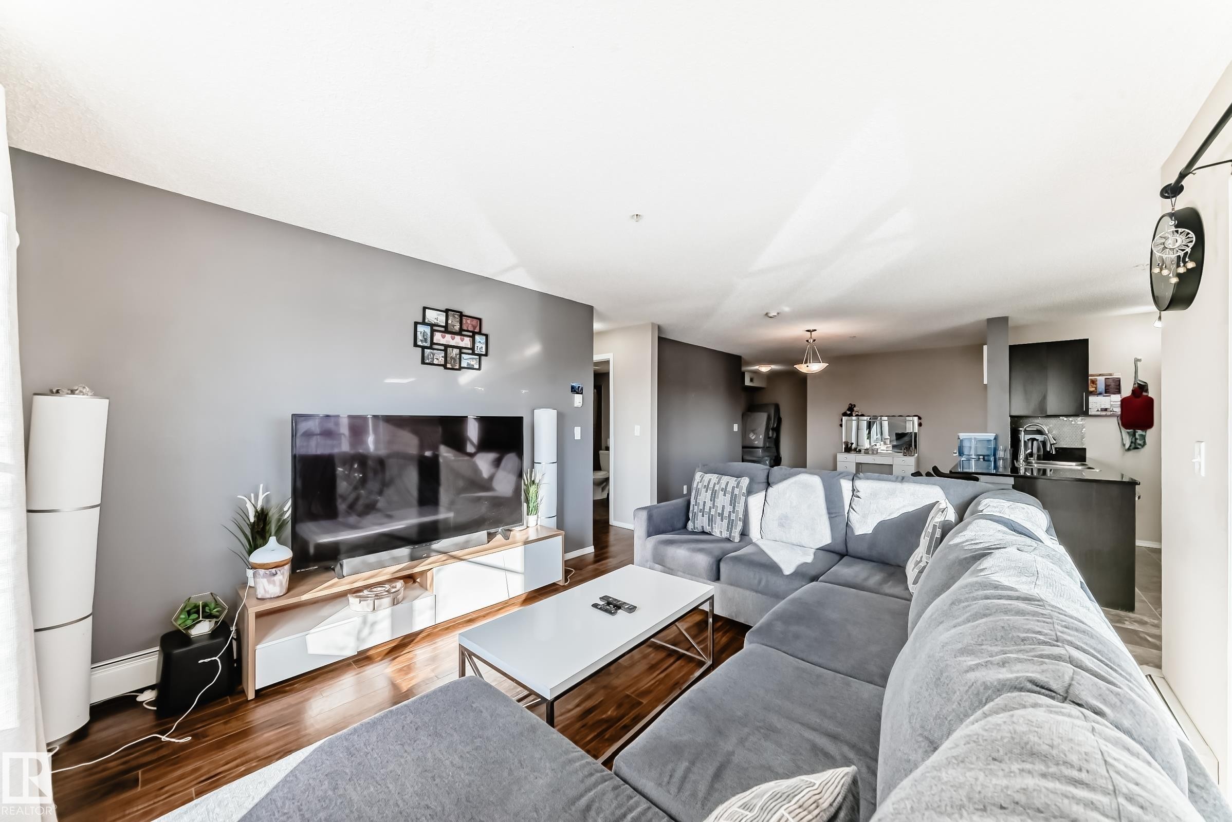 Living room featuring wood finished floors and baseboard heating - 302 530 Watt Boulevard Sw, Edmonton, AB - Indoor Photo Showing Living Room