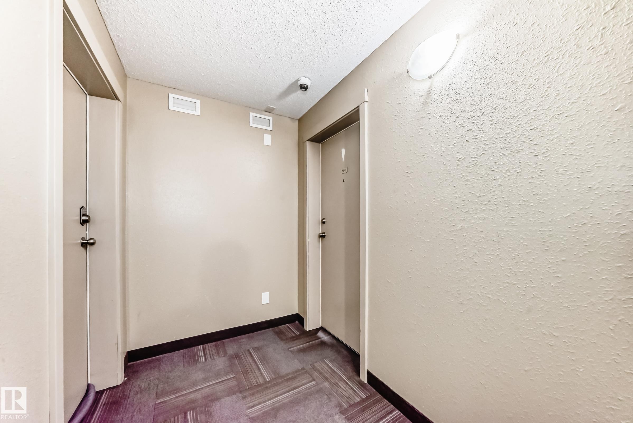 Hall with a textured ceiling and baseboards - 302 530 Watt Boulevard Sw, Edmonton, AB - Indoor Photo Showing Other Room