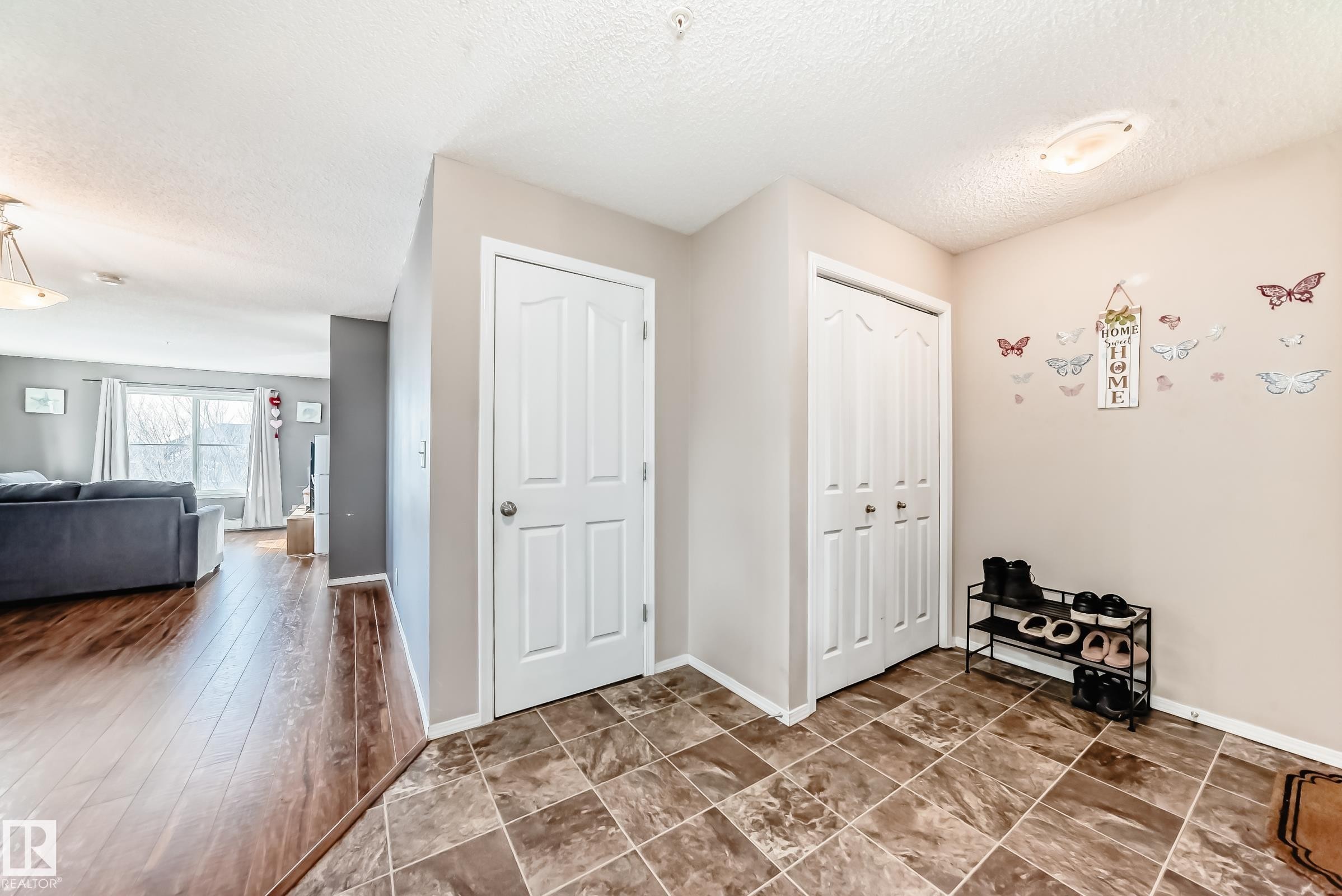 Foyer entrance with baseboards and a textured ceiling - 302 530 Watt Boulevard Sw, Edmonton, AB - Indoor Photo Showing Other Room
