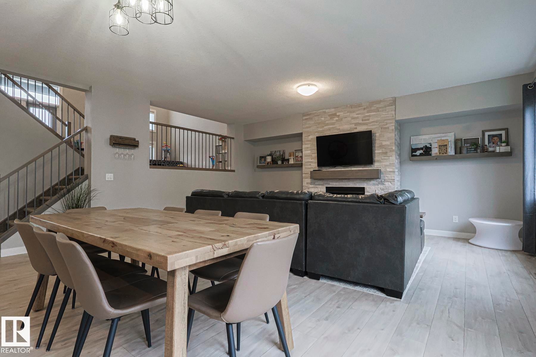 Dining room featuring light wood-style flooring and a fireplace - 2011 201 Street, Edmonton, AB - Indoor Photo Showing Dining Room