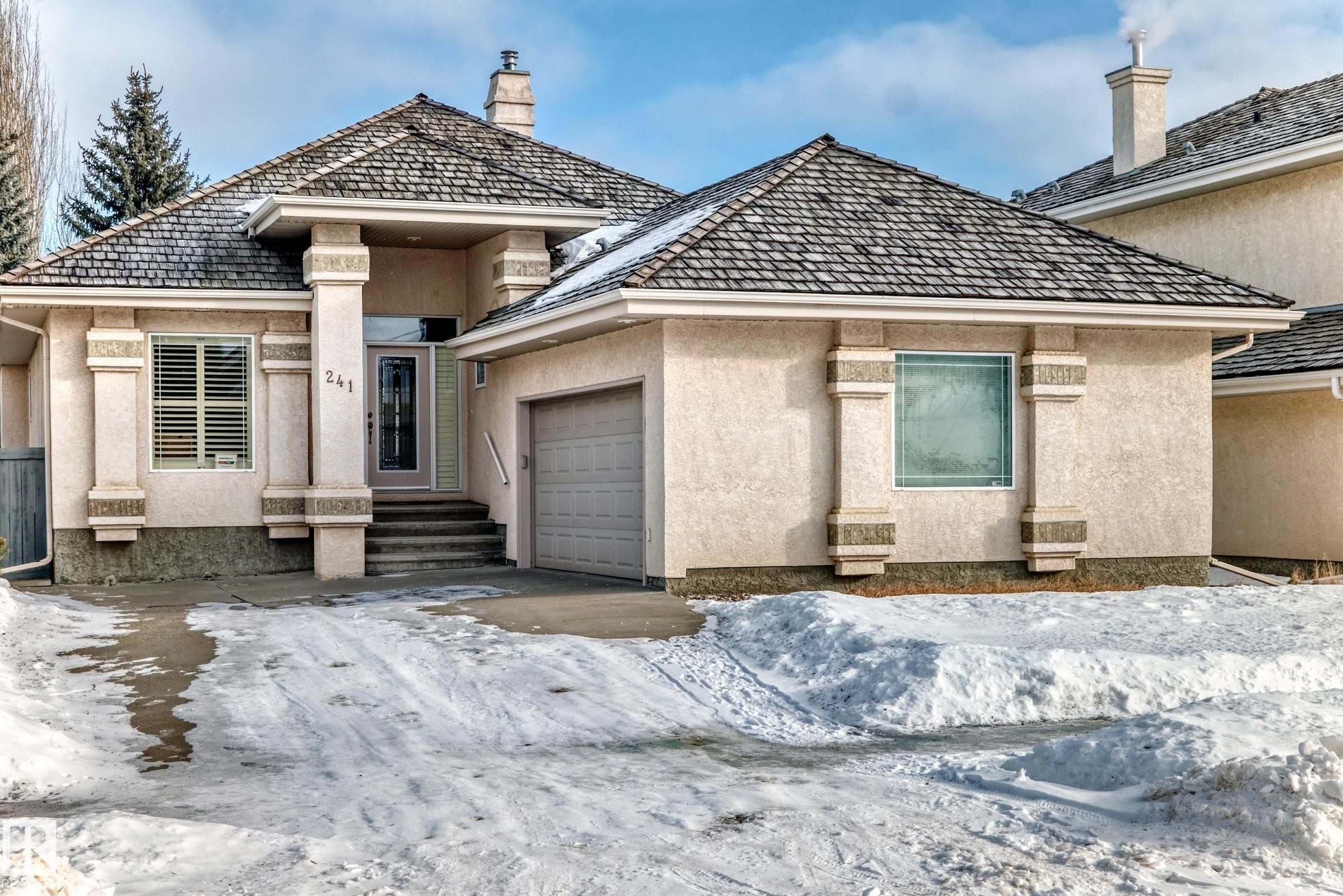 View of front of house with stucco siding and a garage - 241 Darlington Crescent, Edmonton, AB - Outdoor With Facade