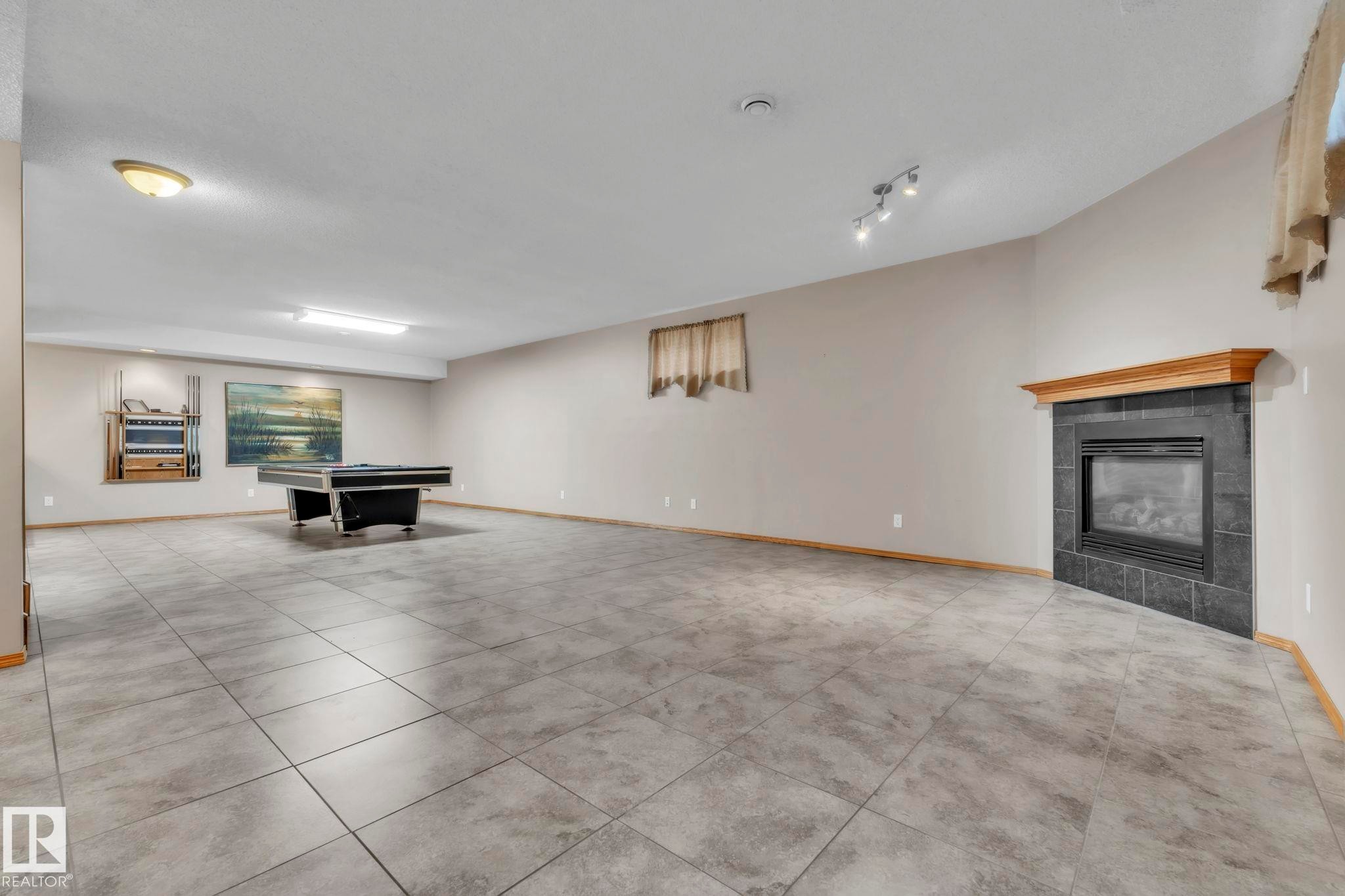 Massive rec room with loads of space for movie nights, games room - 1217 Summerside Drive, Edmonton, AB - Indoor With Fireplace