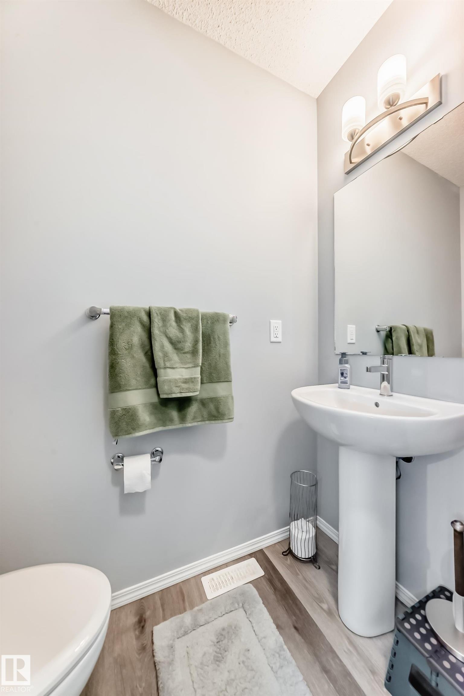 Half bathroom with light wood-type flooring and a textured ceiling - 1002 Stillwater Boulevard, Edmonton, AB - Indoor Photo Showing Bathroom