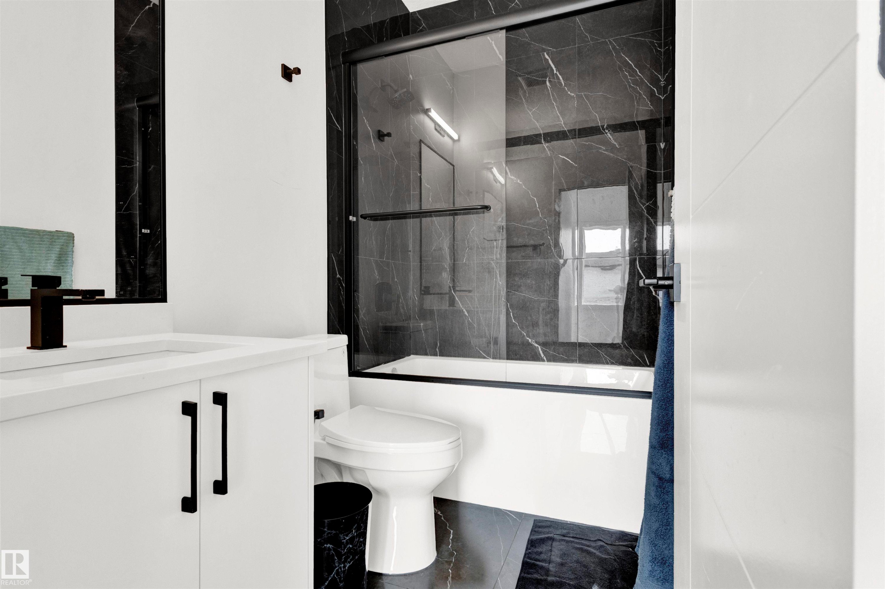 Full bathroom with vanity, bath / shower combo with glass door, and marble finish floors - 9559 85 Street, Edmonton, AB - Indoor Photo Showing Bathroom