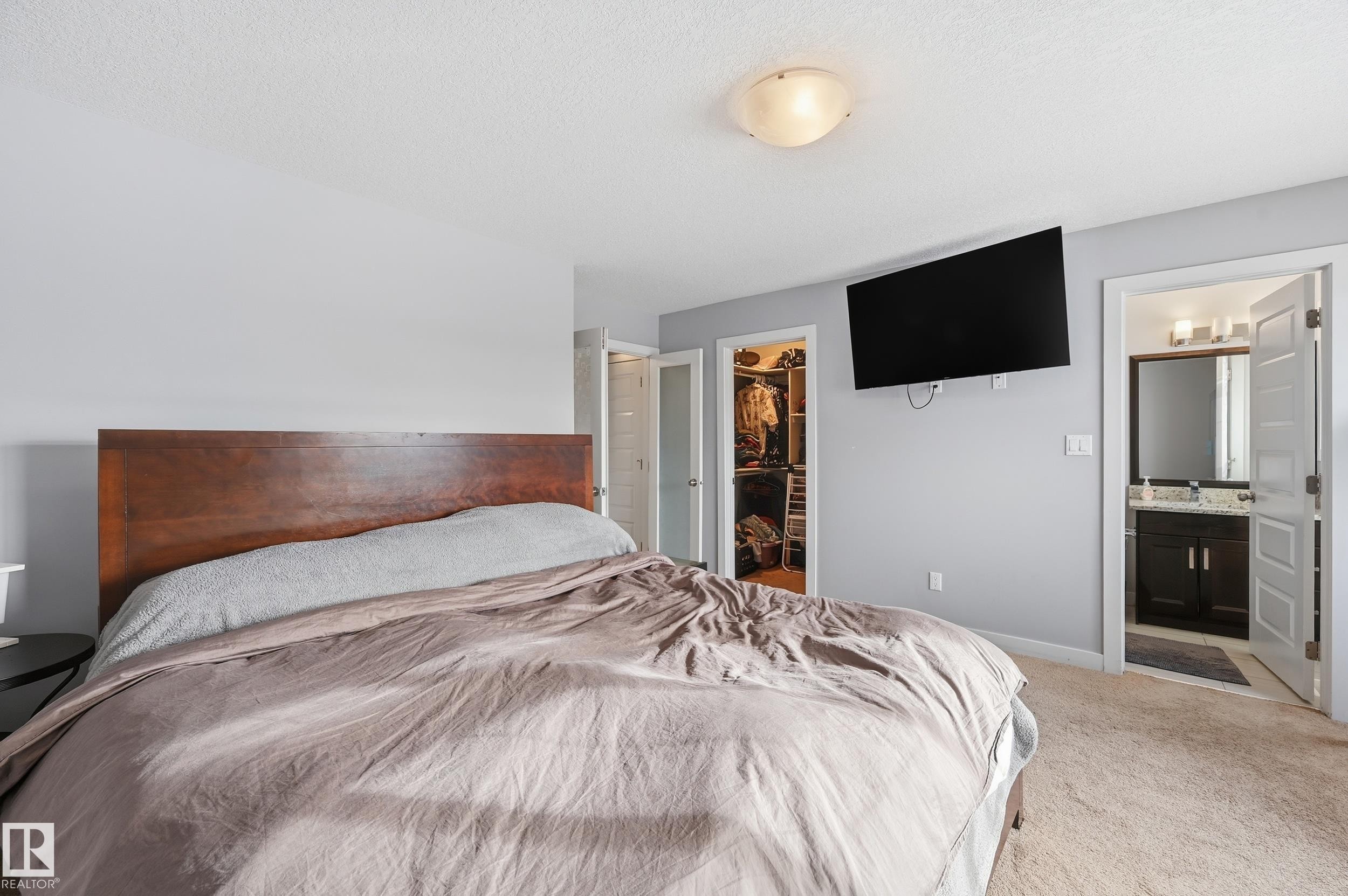 Bedroom featuring a spacious closet, carpet flooring, and connected bathroom - 5978 167C Avenue, Edmonton, AB - Indoor Photo Showing Bedroom