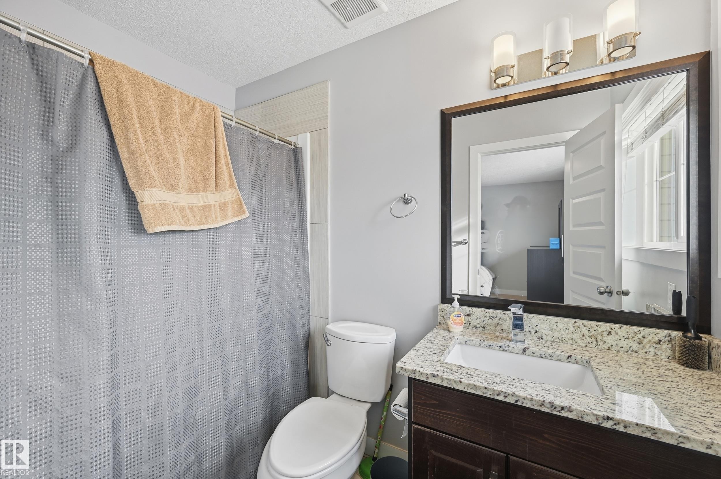 Bathroom with vanity, curtained shower, and a textured ceiling - 5978 167C Avenue, Edmonton, AB - Indoor Photo Showing Bathroom