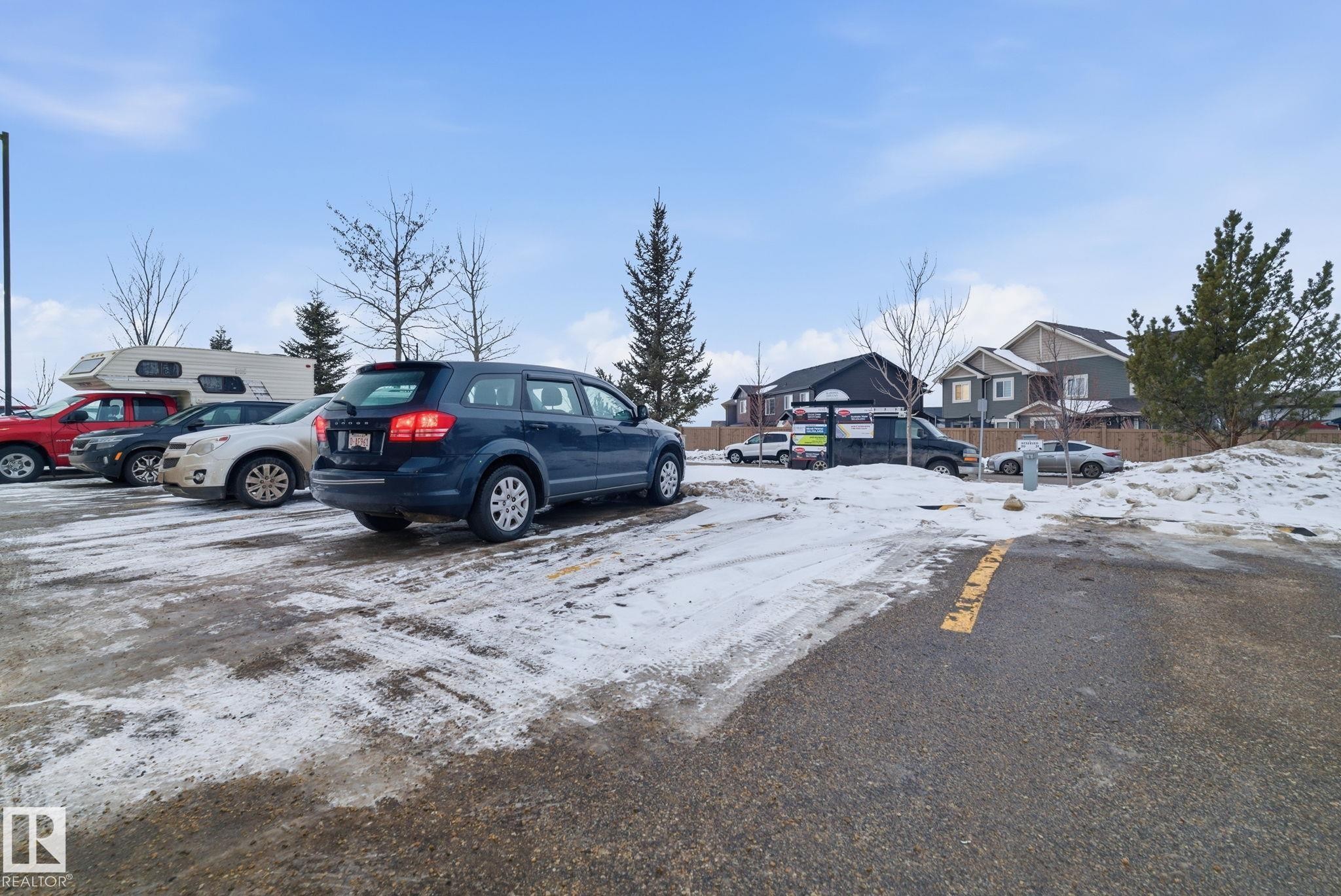 Snow covered parking with uncovered parking and a residential view - 424 1510 Watt Drive, Edmonton, AB - Outdoor