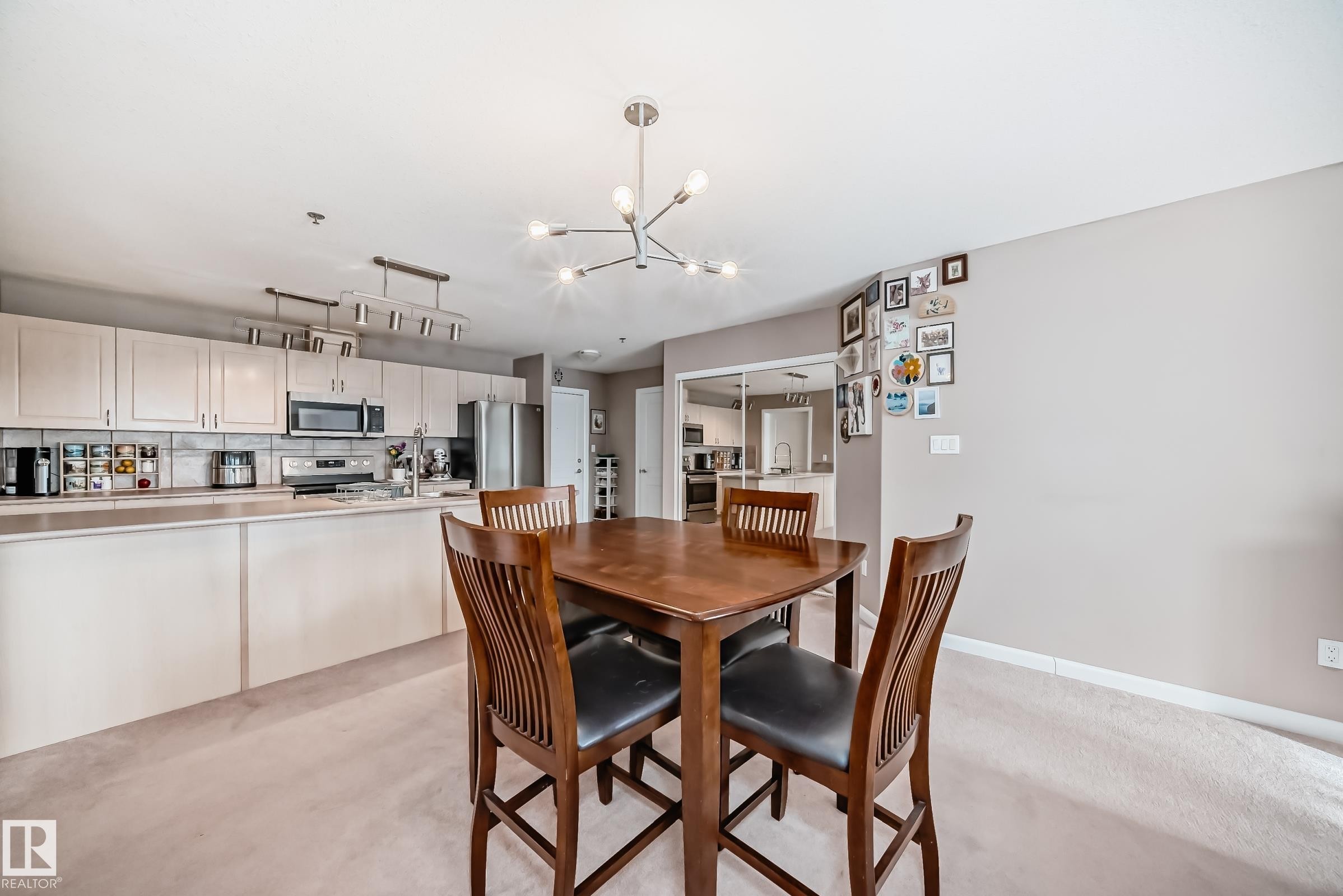 Dining space with suspended lighting and light carpet - 232 530 Hooke Road, Edmonton, AB - Indoor