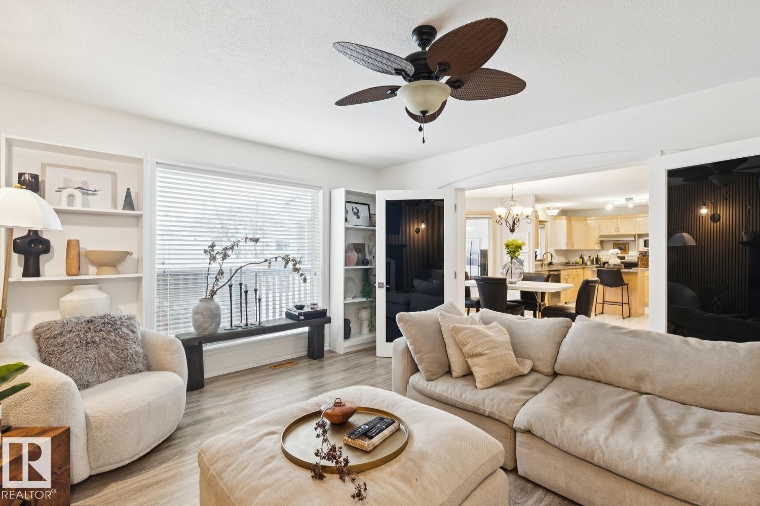 Living room featuring light wood-style flooring, ceiling fan, healthy amount of natural light, a chandelier, and a textured ceiling - 8617 158A Avenue, Edmonton, AB - Indoor Photo Showing Living Room