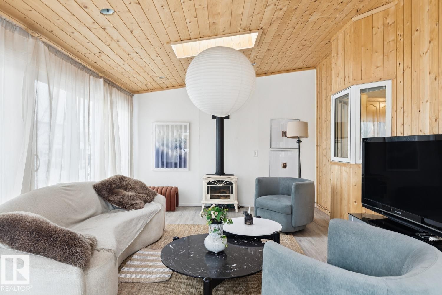 Living area with a wood stove, wooden ceiling, wood finished floors, and wooden walls - 8617 158A Avenue, Edmonton, AB - Indoor Photo Showing Living Room