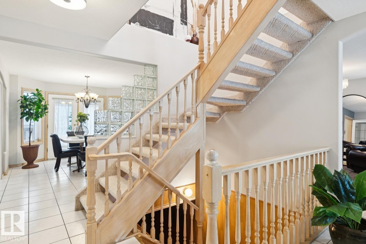 Stairway featuring tile patterned flooring, a chandelier, and arched walkways - 8617 158A Avenue, Edmonton, AB - Indoor Photo Showing Other Room