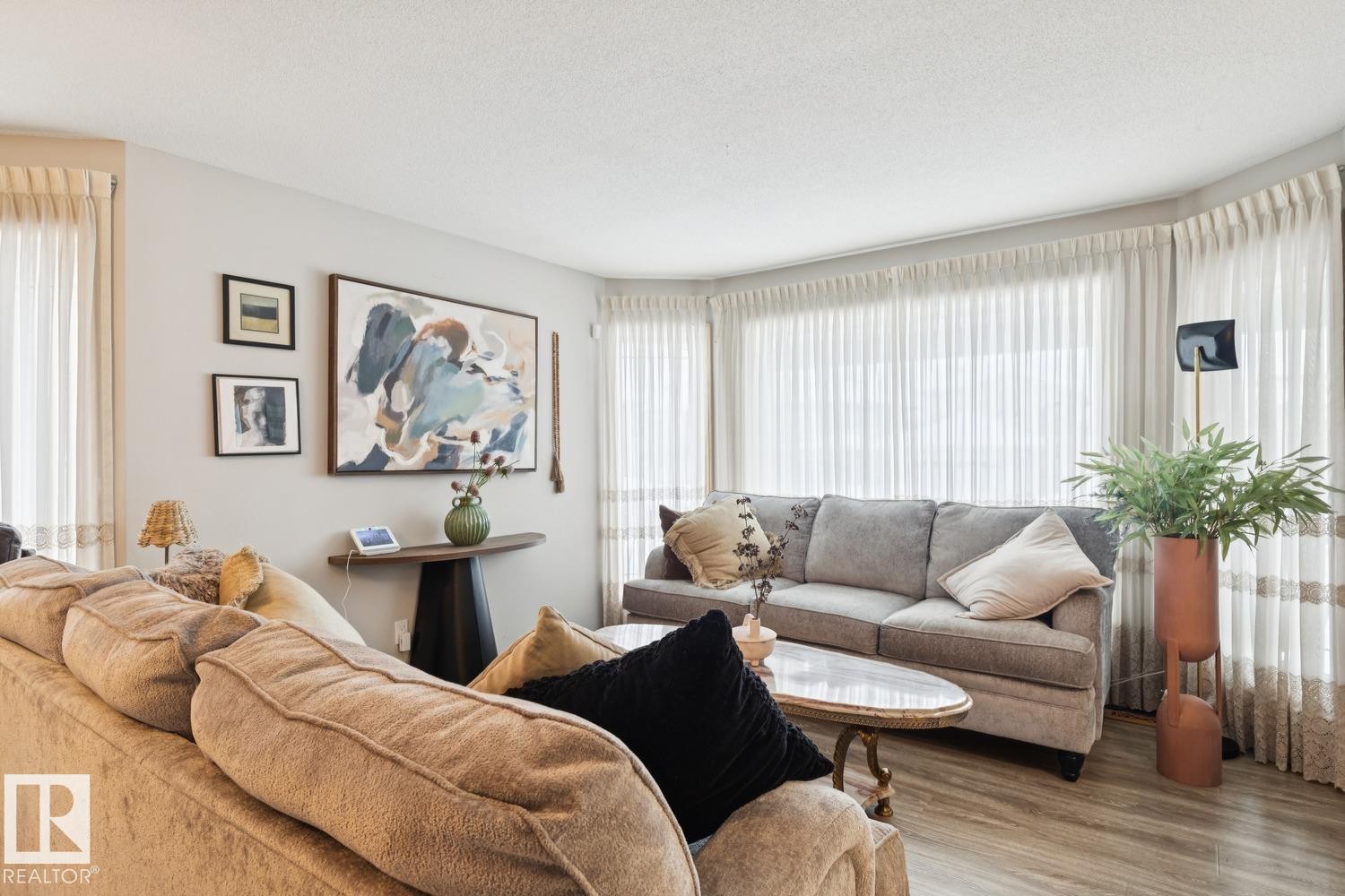 Living area featuring healthy amount of natural light, wood finished floors, and a textured ceiling - 8617 158A Avenue, Edmonton, AB - Indoor Photo Showing Living Room