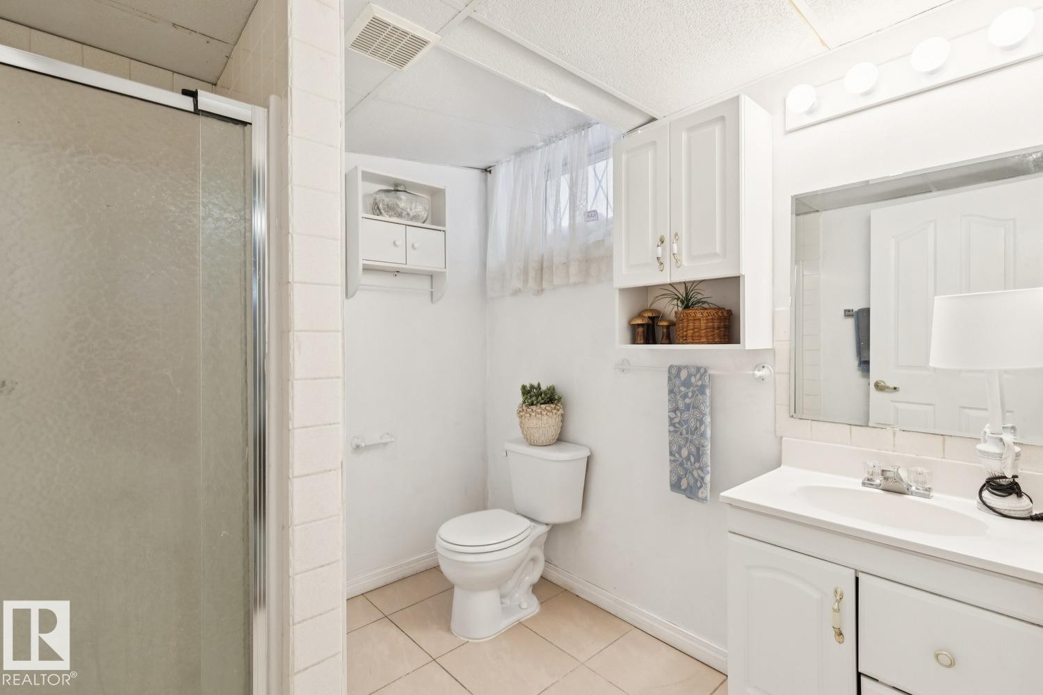 Bathroom with vanity, a stall shower, and light tile patterned floors - 8617 158A Avenue, Edmonton, AB - Indoor Photo Showing Bathroom