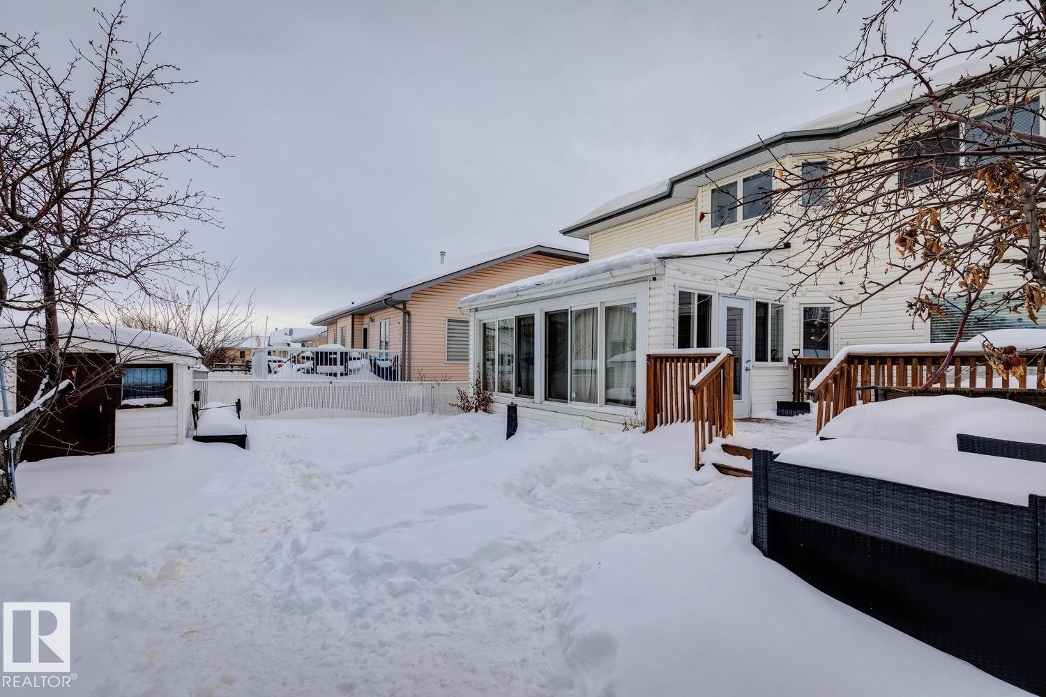 Snow covered property featuring a sunroom, an outdoor hangout area, and a deck - 8617 158A Avenue, Edmonton, AB - Outdoor