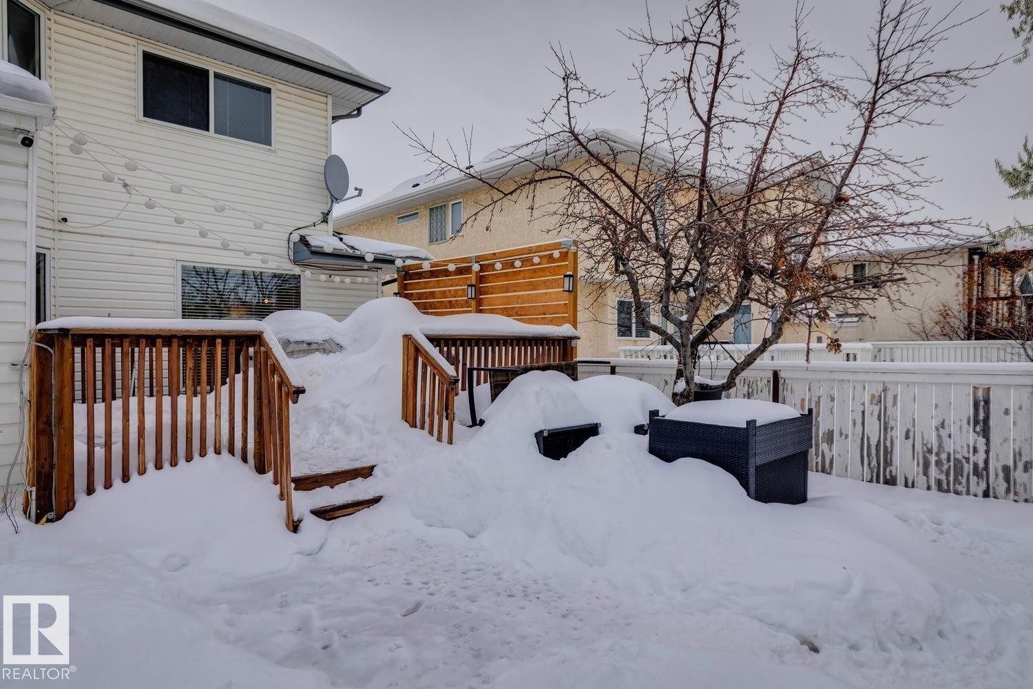 Yard layered in snow with a deck - 8617 158A Avenue, Edmonton, AB - Outdoor With Exterior