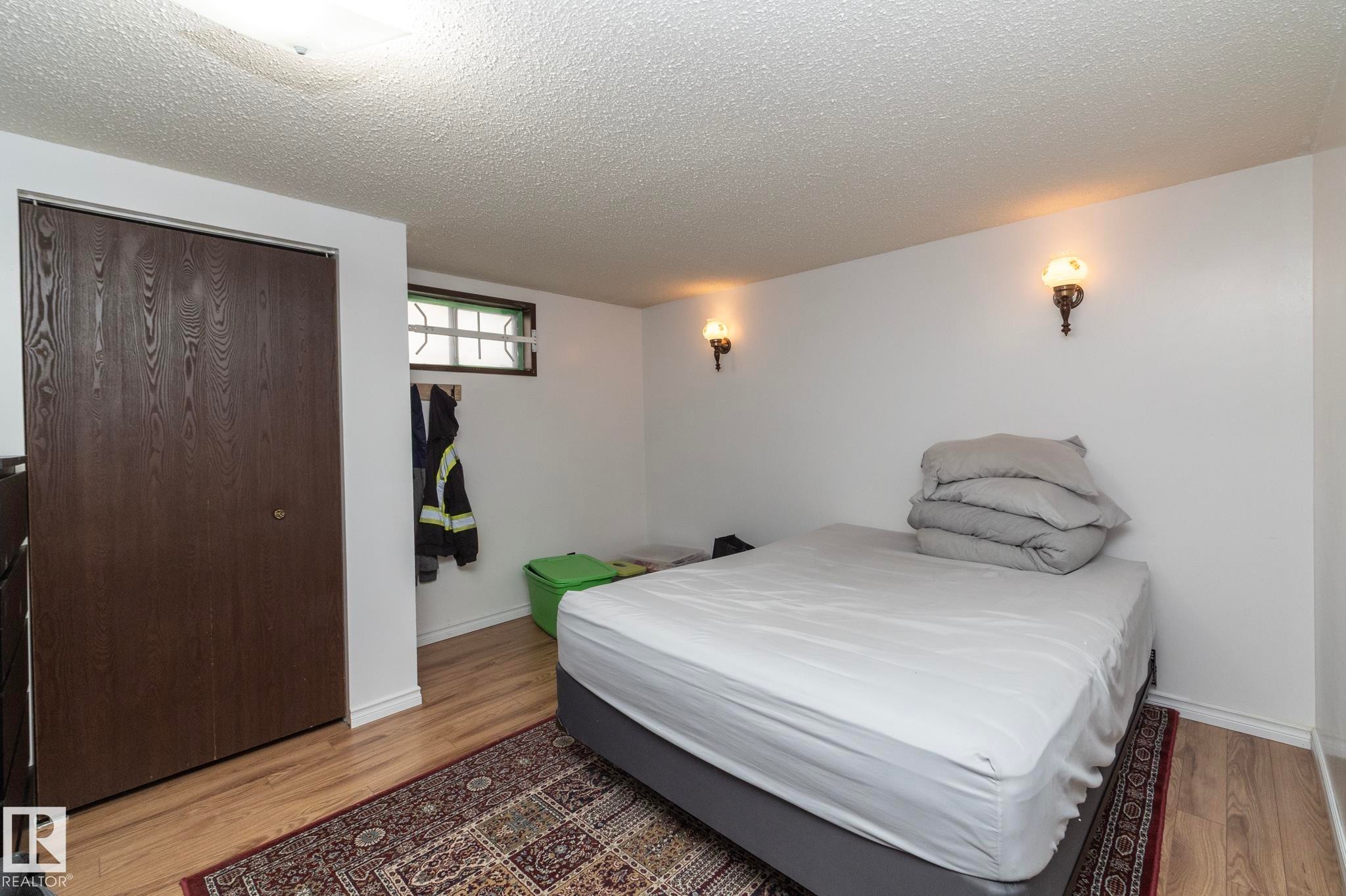 Bedroom with a textured ceiling, a closet, and light wood-style floors - 9020 152 Avenue, Edmonton, AB - Indoor Photo Showing Bedroom