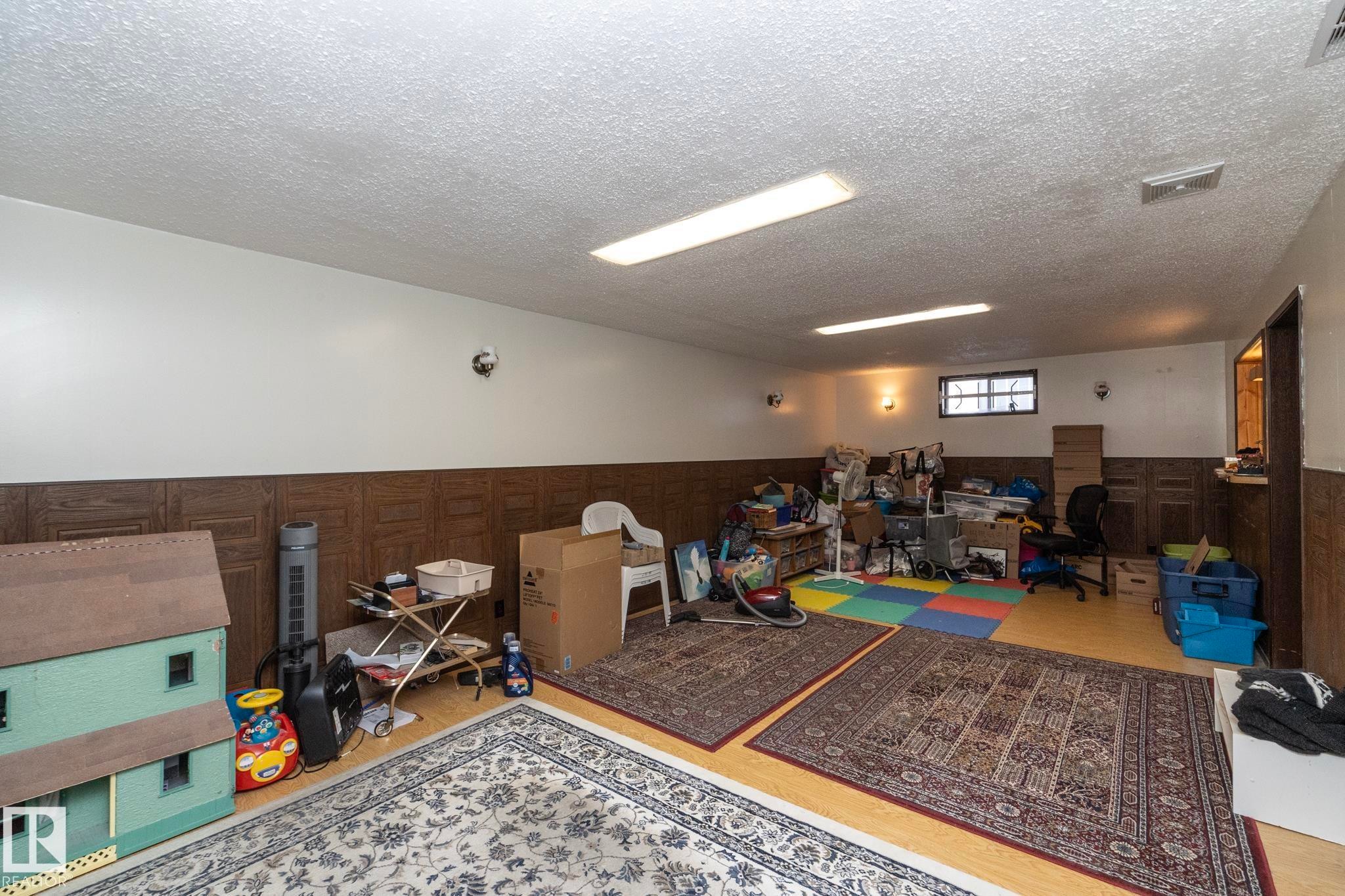 Game room with a wainscoted wall, an office area, a textured ceiling, and wood finished floors - 9020 152 Avenue, Edmonton, AB - Indoor Photo Showing Other Room