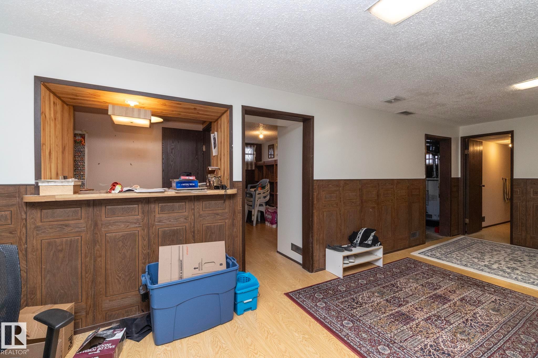 Interior space featuring wainscoting, a textured ceiling, and wood walls - 9020 152 Avenue, Edmonton, AB - Indoor Photo Showing Other Room