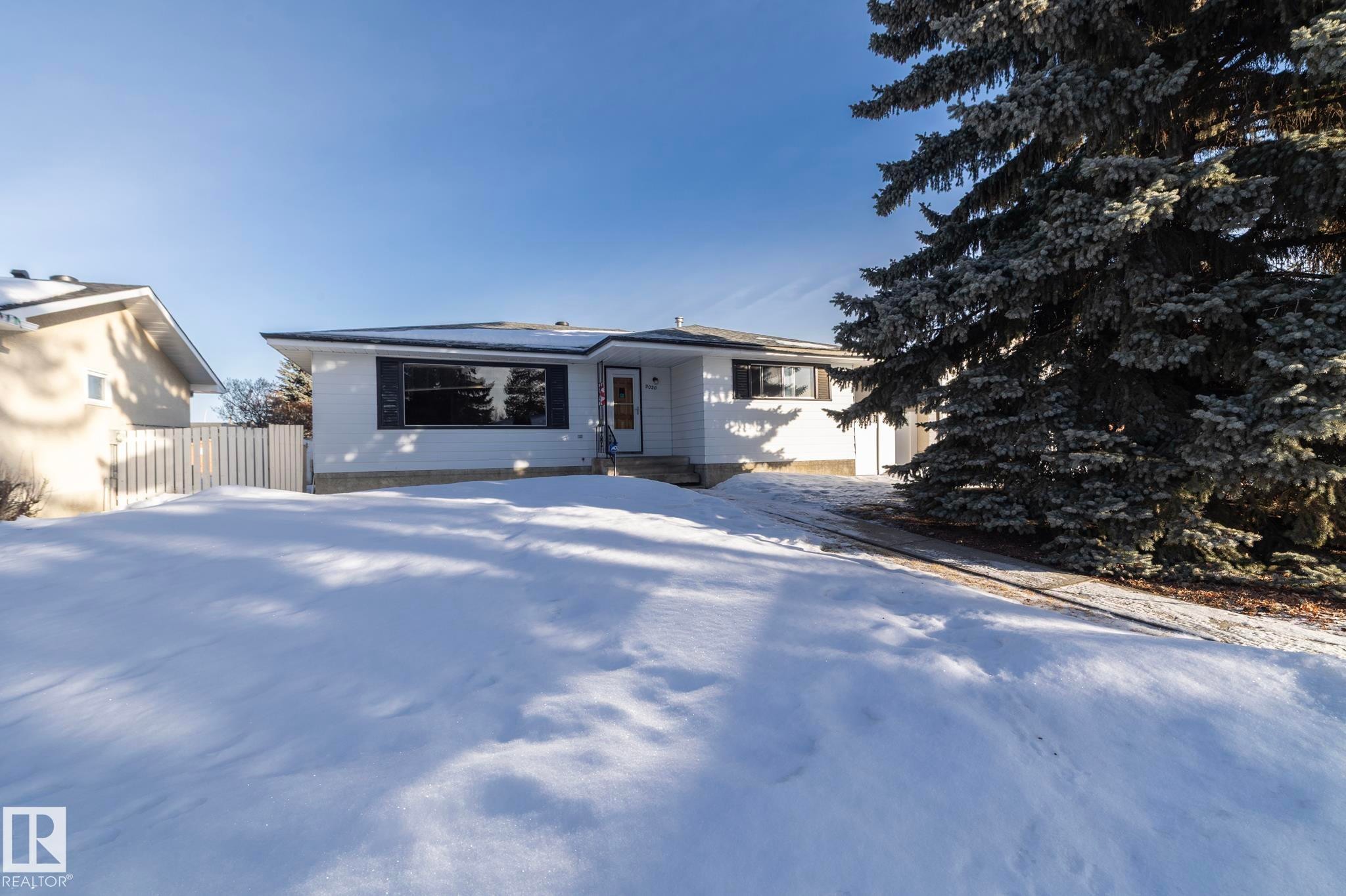 Ranch-style house with roof mounted solar panels and a gate - 9020 152 Avenue, Edmonton, AB - Outdoor