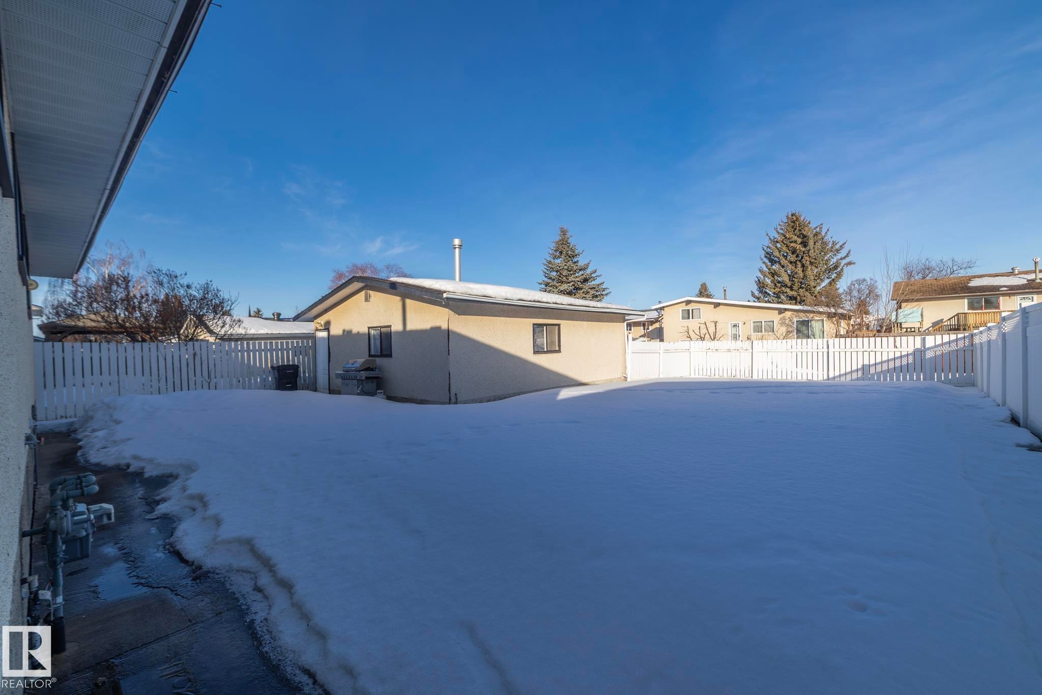 Yard layered in snow with a fenced backyard - 9020 152 Avenue, Edmonton, AB - Outdoor