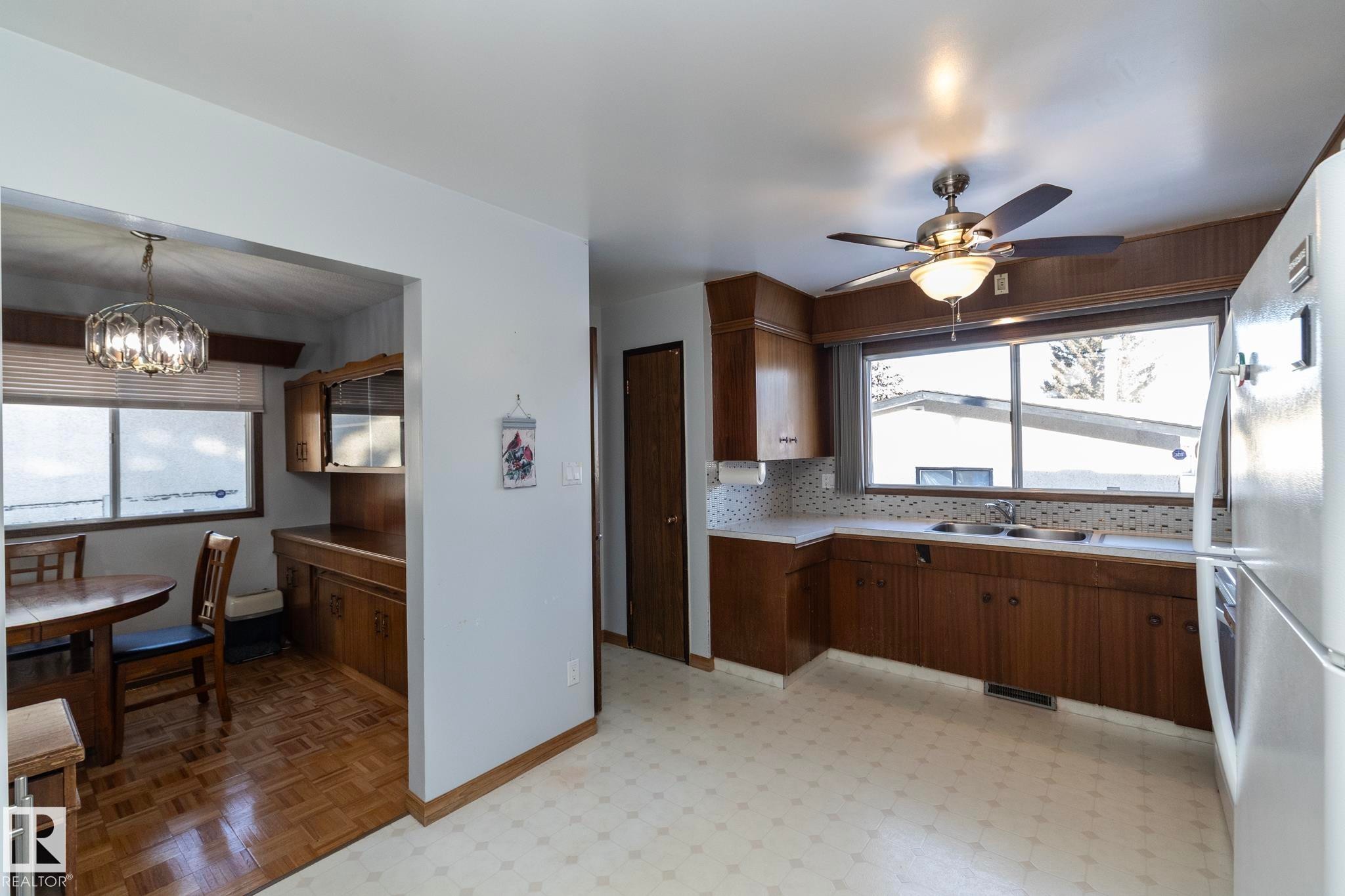 Kitchen featuring light countertops, freestanding refrigerator, a ceiling fan, and healthy amount of natural light - 9020 152 Avenue, Edmonton, AB - Indoor