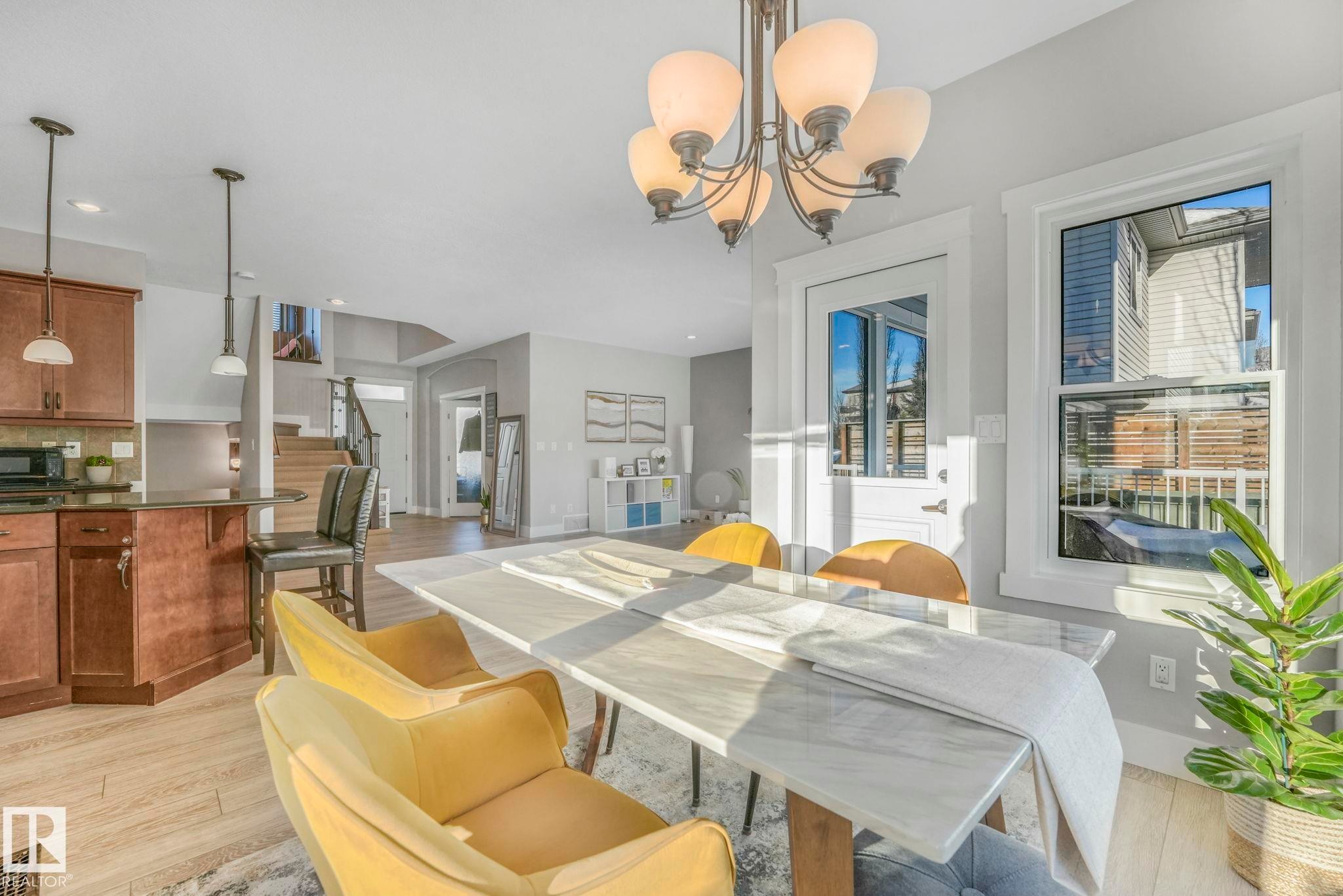 Dining space with light wood-type flooring, a chandelier, stairs, and recessed lighting - 2307 Rutherford Way, Edmonton, AB - Indoor Photo Showing Dining Room