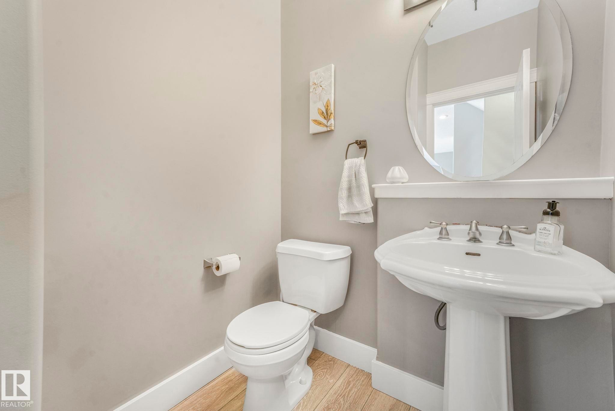 Half bath with baseboards and wood finished floors - 2307 Rutherford Way, Edmonton, AB - Indoor Photo Showing Bathroom
