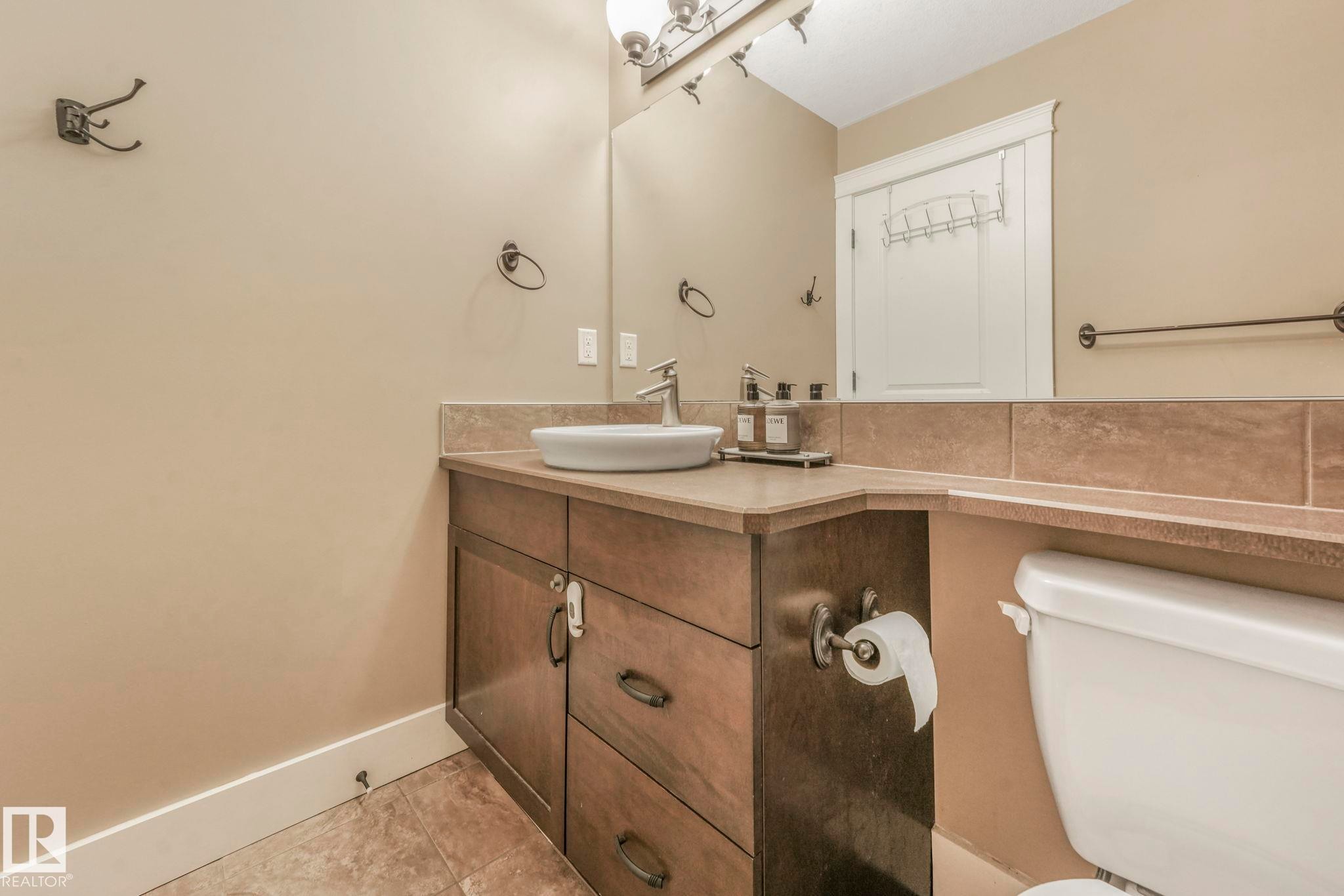Half bath featuring vanity and light tile patterned flooring - 2307 Rutherford Way, Edmonton, AB - Indoor Photo Showing Bathroom