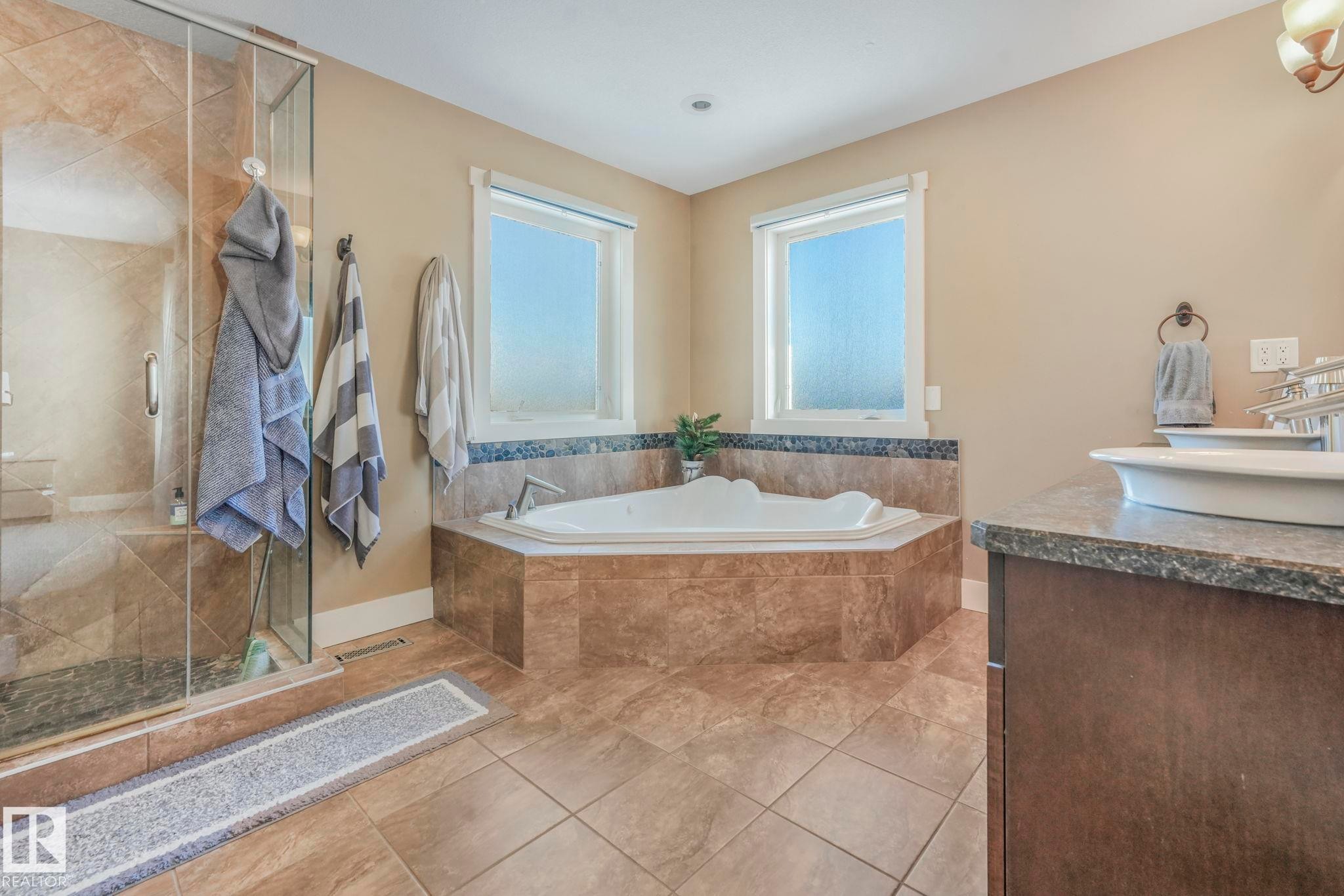 Bathroom with a shower stall, a garden tub, vanity, and light tile patterned floors - 2307 Rutherford Way, Edmonton, AB - Indoor Photo Showing Bathroom