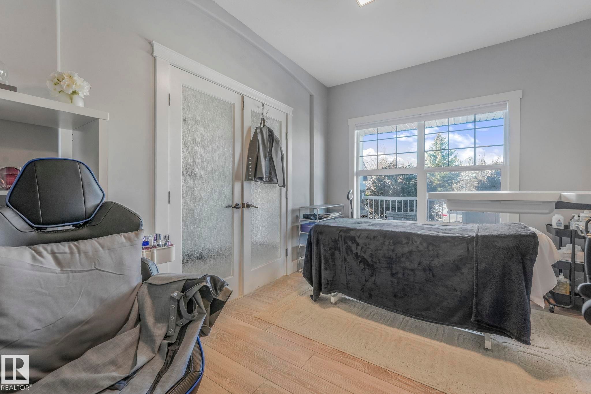 Bedroom with wood finished floors, a closet, and french doors - 2307 Rutherford Way, Edmonton, AB - Indoor
