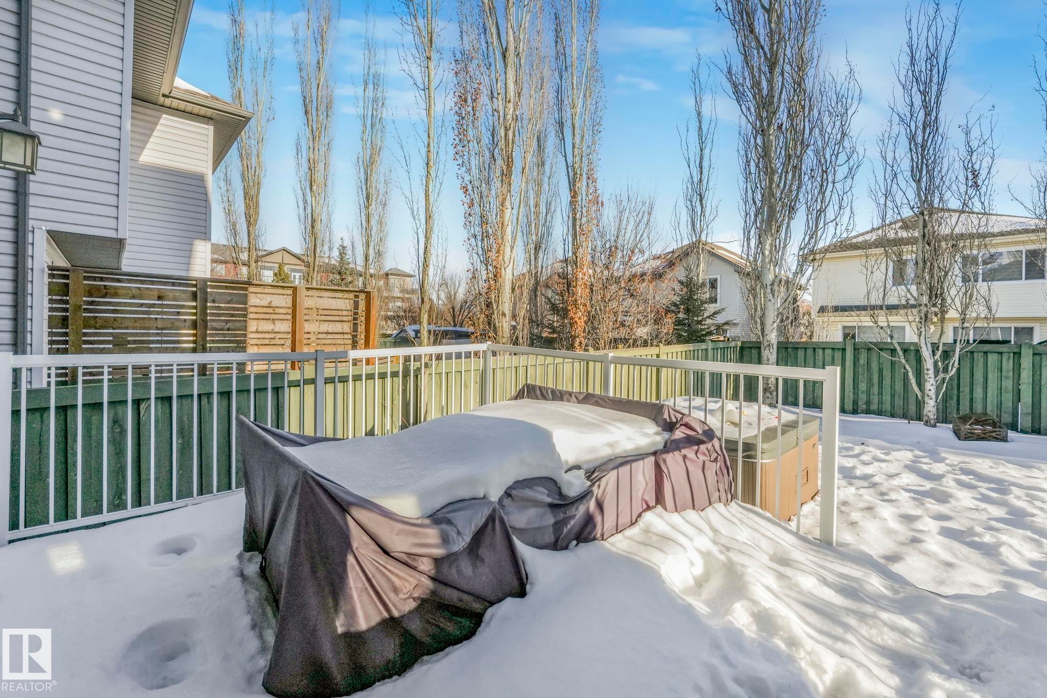 Fenced backyard featuring a hot tub, a deck, and a residential view - 2307 Rutherford Way, Edmonton, AB - Outdoor With Exterior