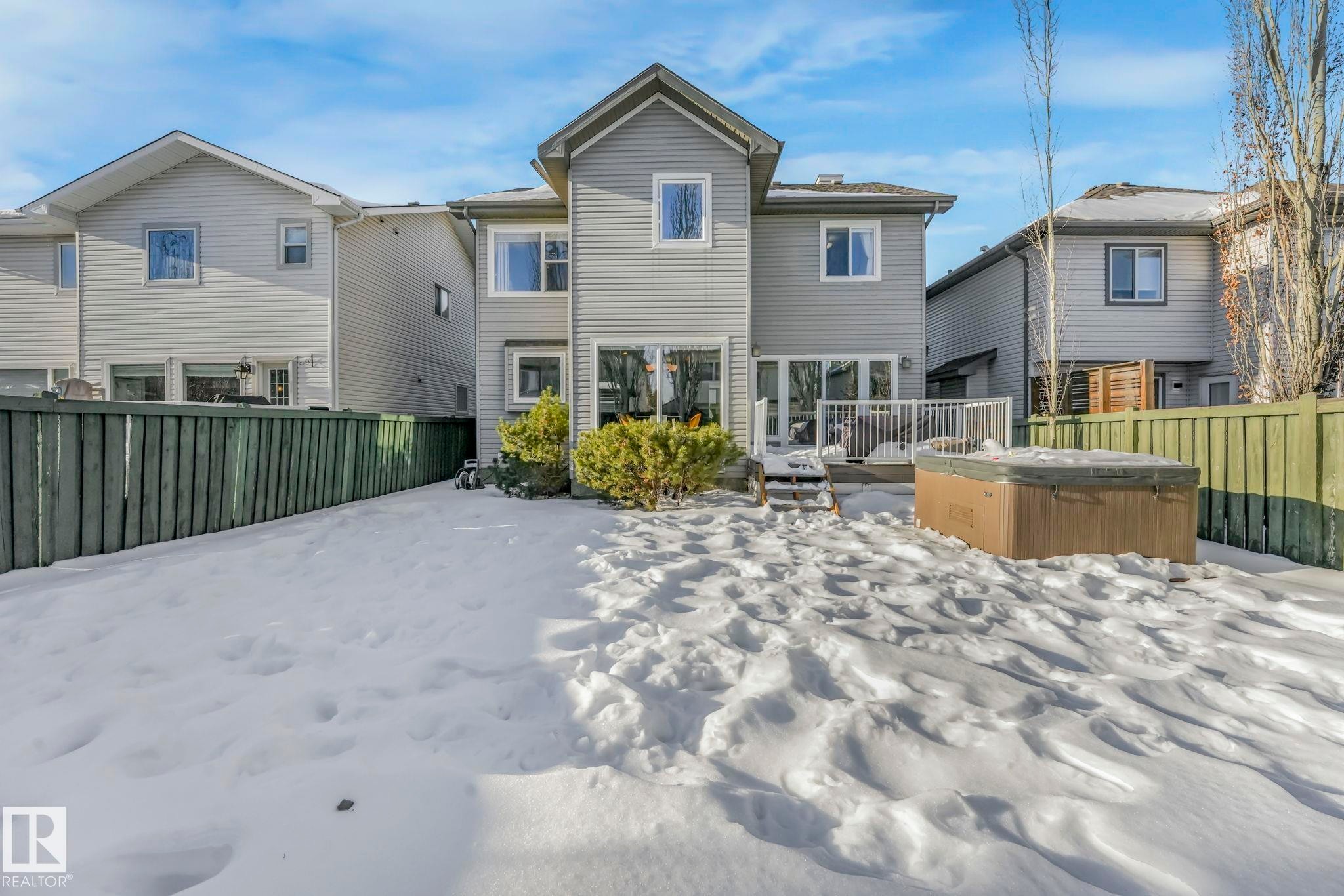 Snow covered property featuring a fenced backyard and a hot tub - 2307 Rutherford Way, Edmonton, AB - Outdoor