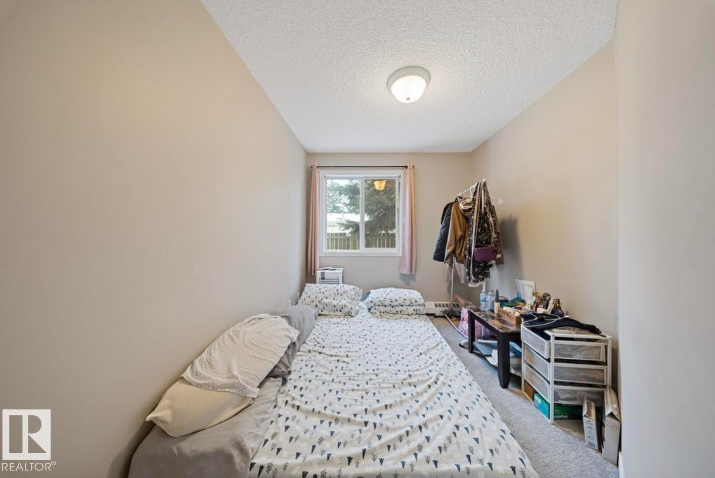 Carpeted bedroom with a textured ceiling - 103 12110 119 Ave, Edmonton, AB - Indoor Photo Showing Bedroom