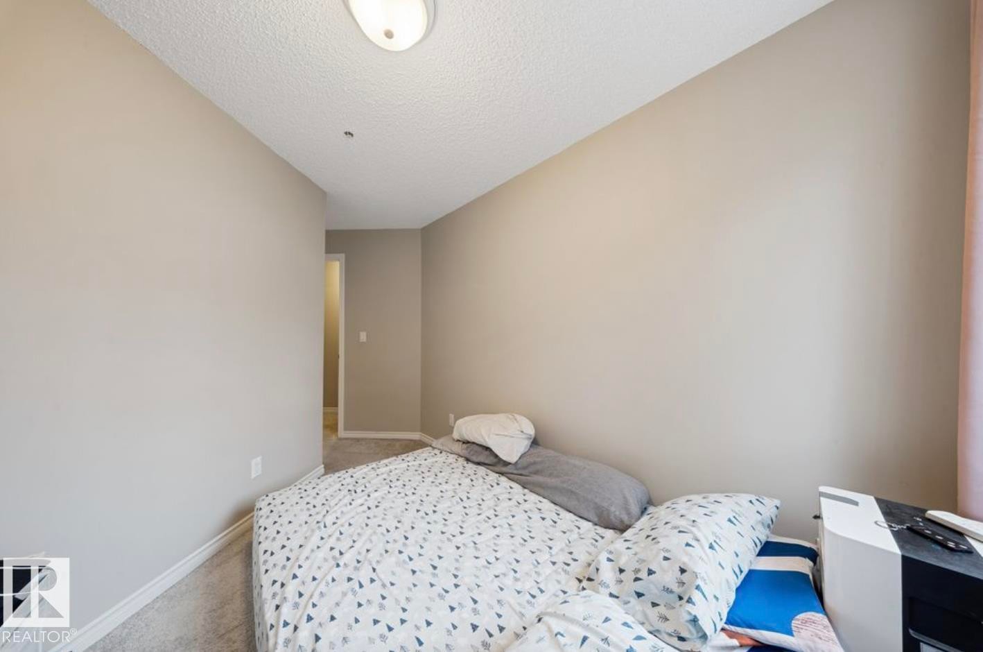 Bedroom with a textured ceiling and carpet flooring - 103 12110 119 Ave, Edmonton, AB - Indoor Photo Showing Bedroom