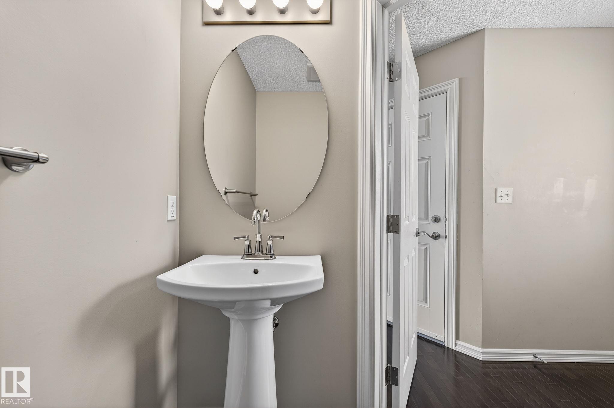Bathroom with dark wood-type flooring and a textured ceiling - 2338 Casselman Crescent, Edmonton, AB - Indoor Photo Showing Bathroom