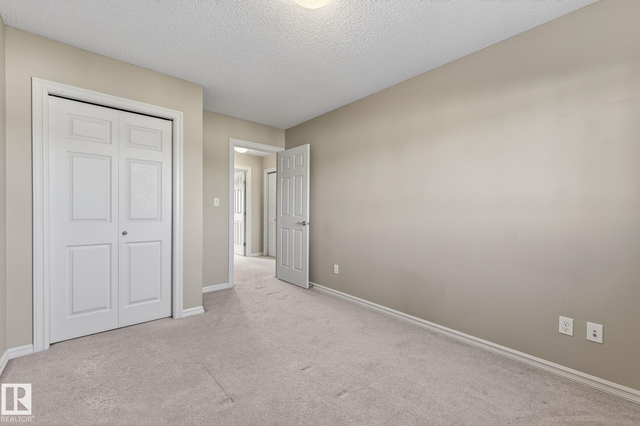 Unfurnished bedroom featuring carpet flooring, a textured ceiling, and a closet - 2338 Casselman Crescent, Edmonton, AB - Indoor Photo Showing Other Room