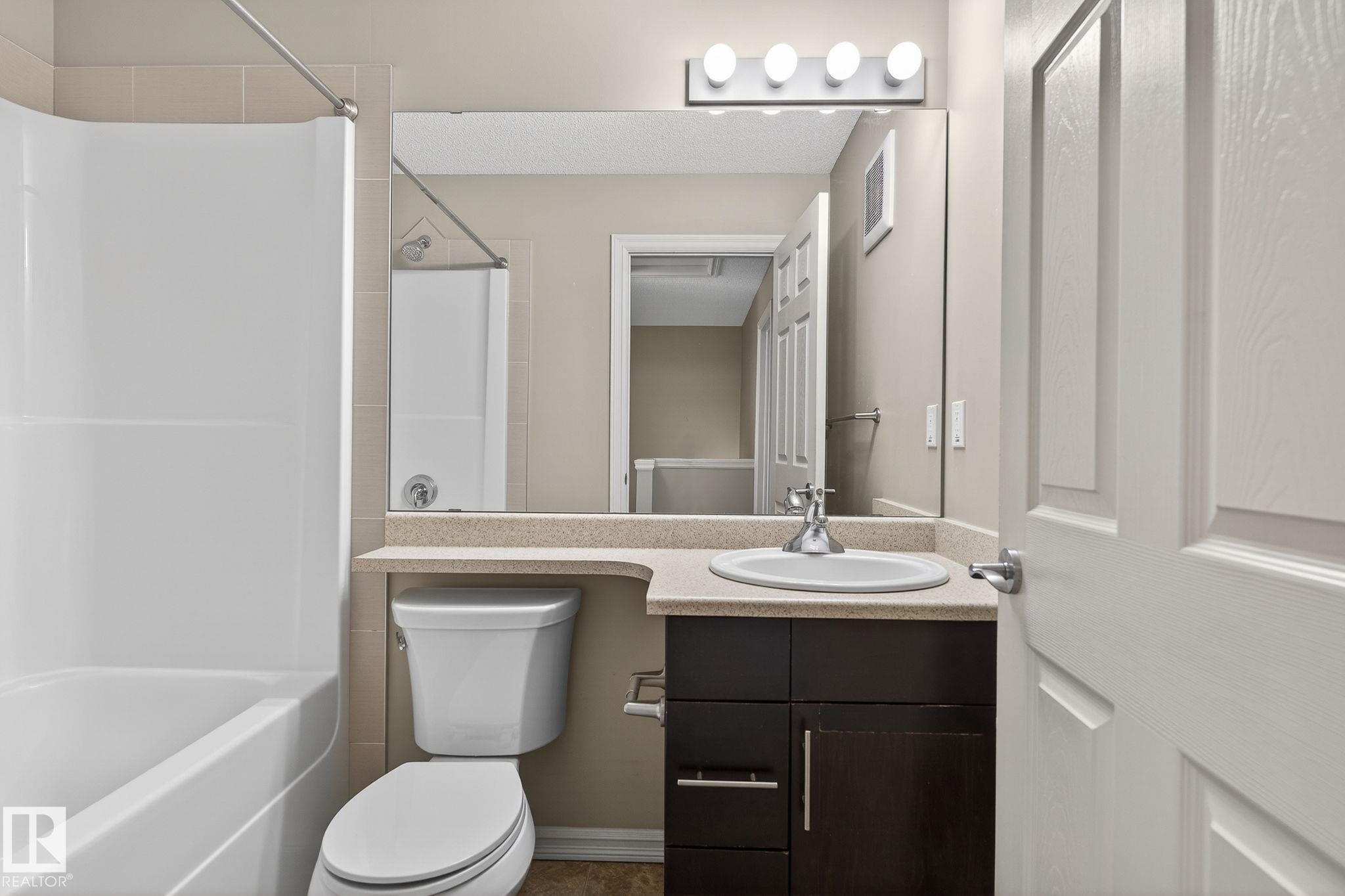Bathroom featuring vanity and bathing tub / shower combination - 2338 Casselman Crescent, Edmonton, AB - Indoor Photo Showing Bathroom