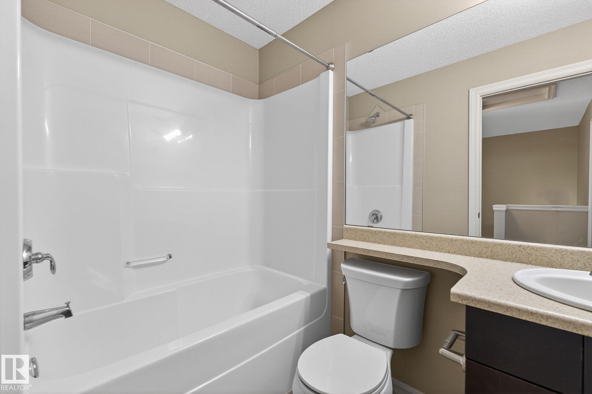 Full bathroom with vanity, tub / shower combination, and a textured ceiling - 2338 Casselman Crescent, Edmonton, AB - Indoor Photo Showing Bathroom