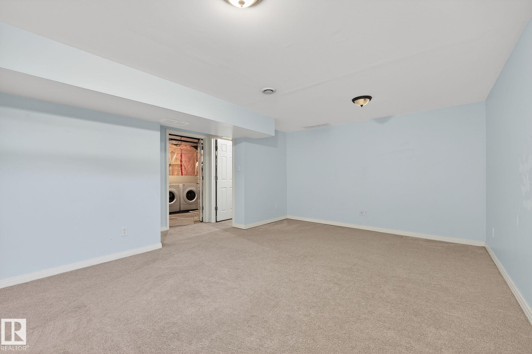 Empty room featuring light colored carpet and washer and dryer - 2338 Casselman Crescent, Edmonton, AB - Indoor Photo Showing Other Room